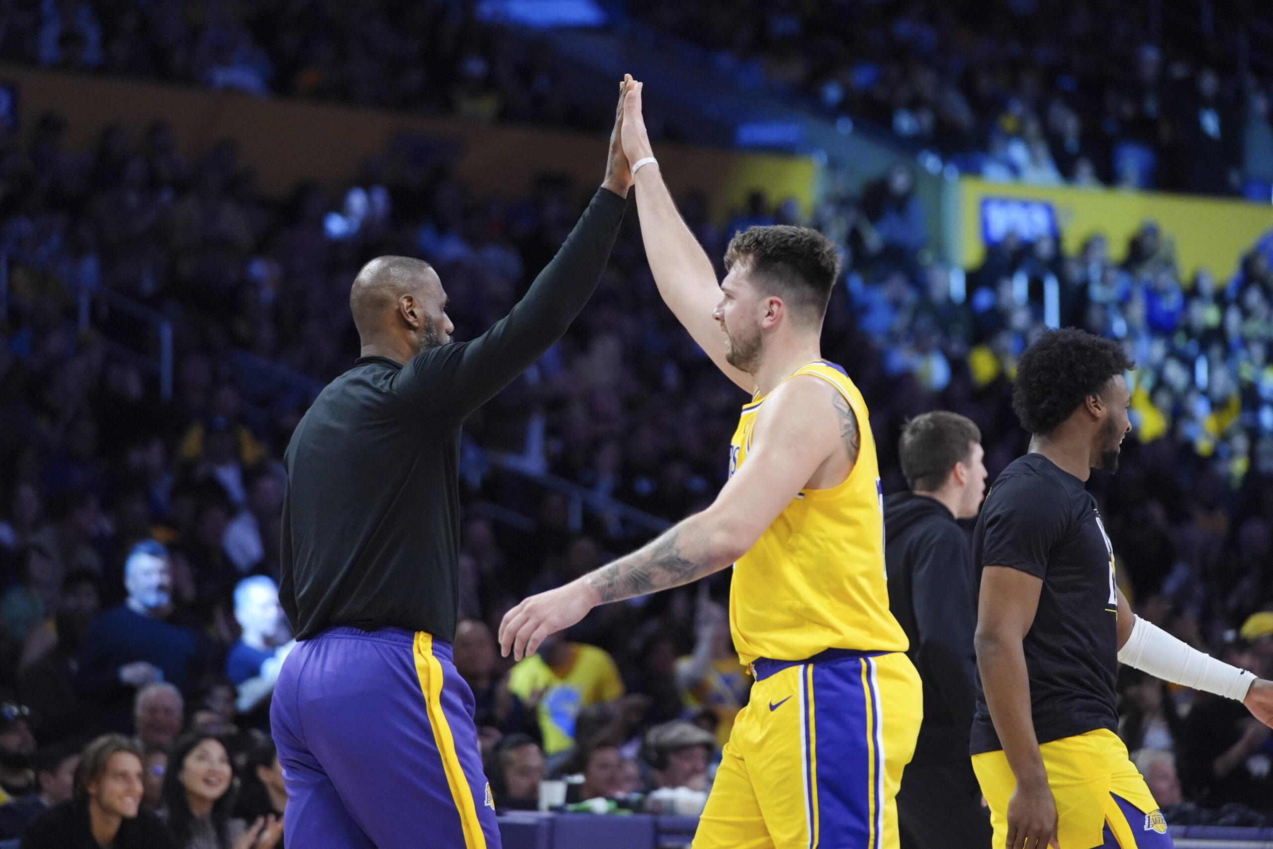 Lakers stars LeBron James, left, and Luka Doncic high-five during...