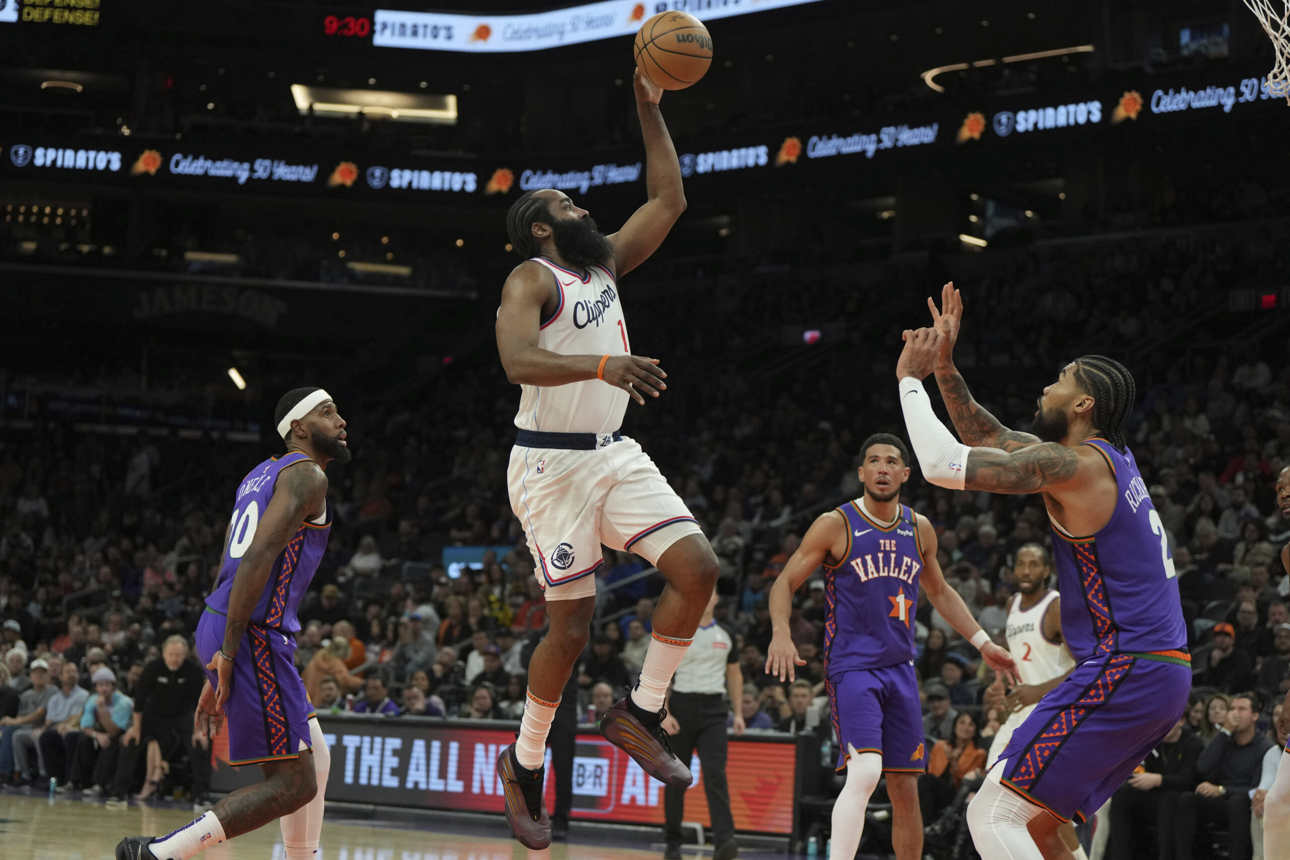 Clippers guard James Harden (1) shoots between Phoenix Suns forward...