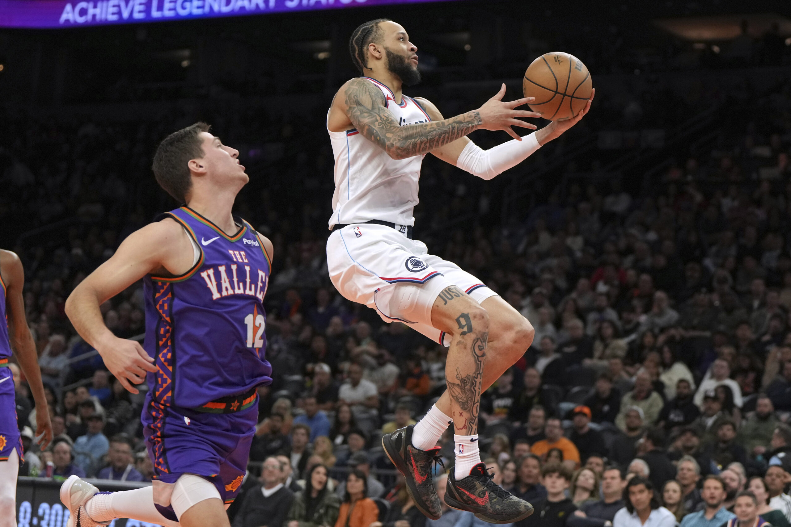 Clippers guard Amir Coffey drives past Phoenix Suns guard Collin...