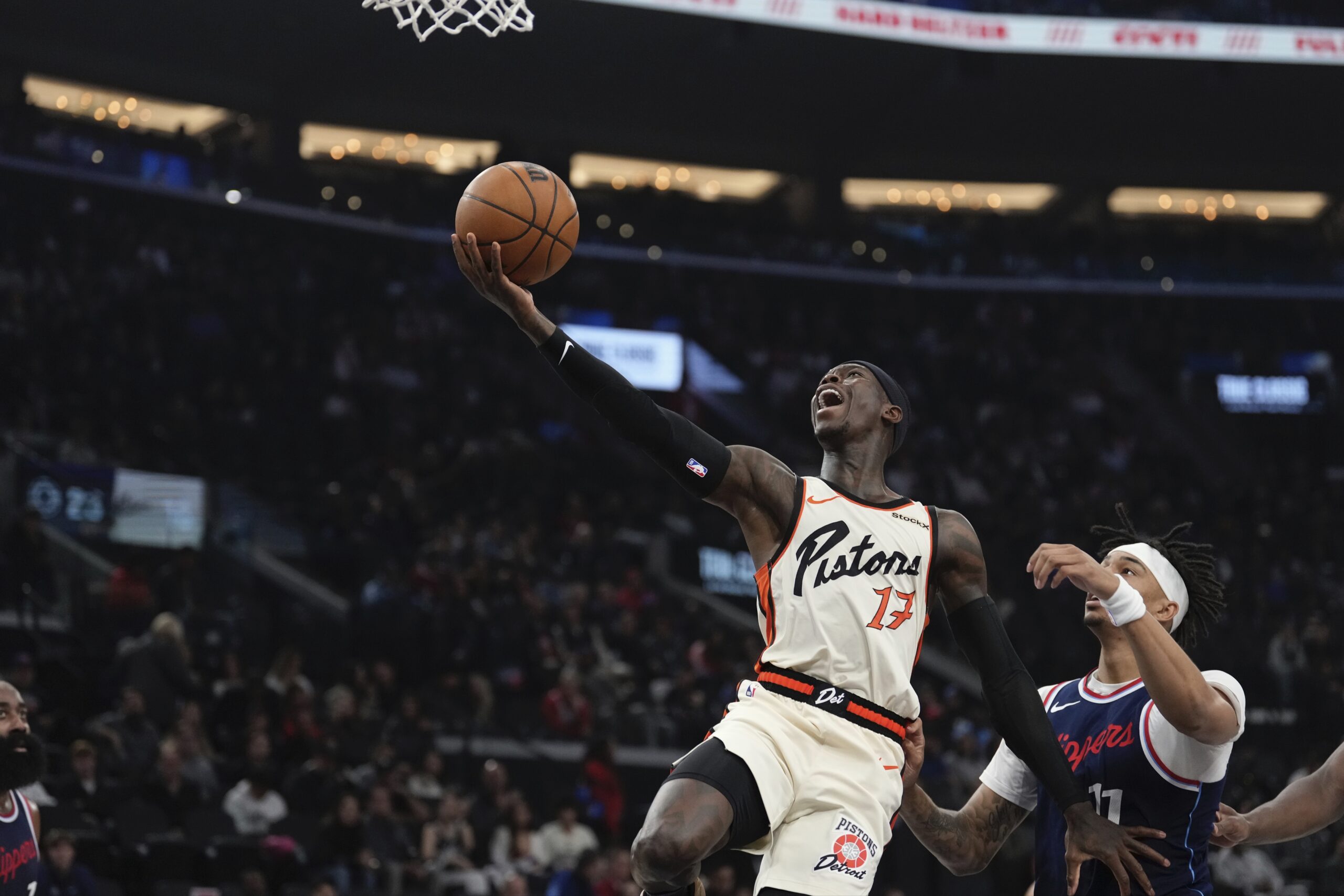 Detroit Pistons guard Dennis Schroder, left, shoots as Clippers guard...