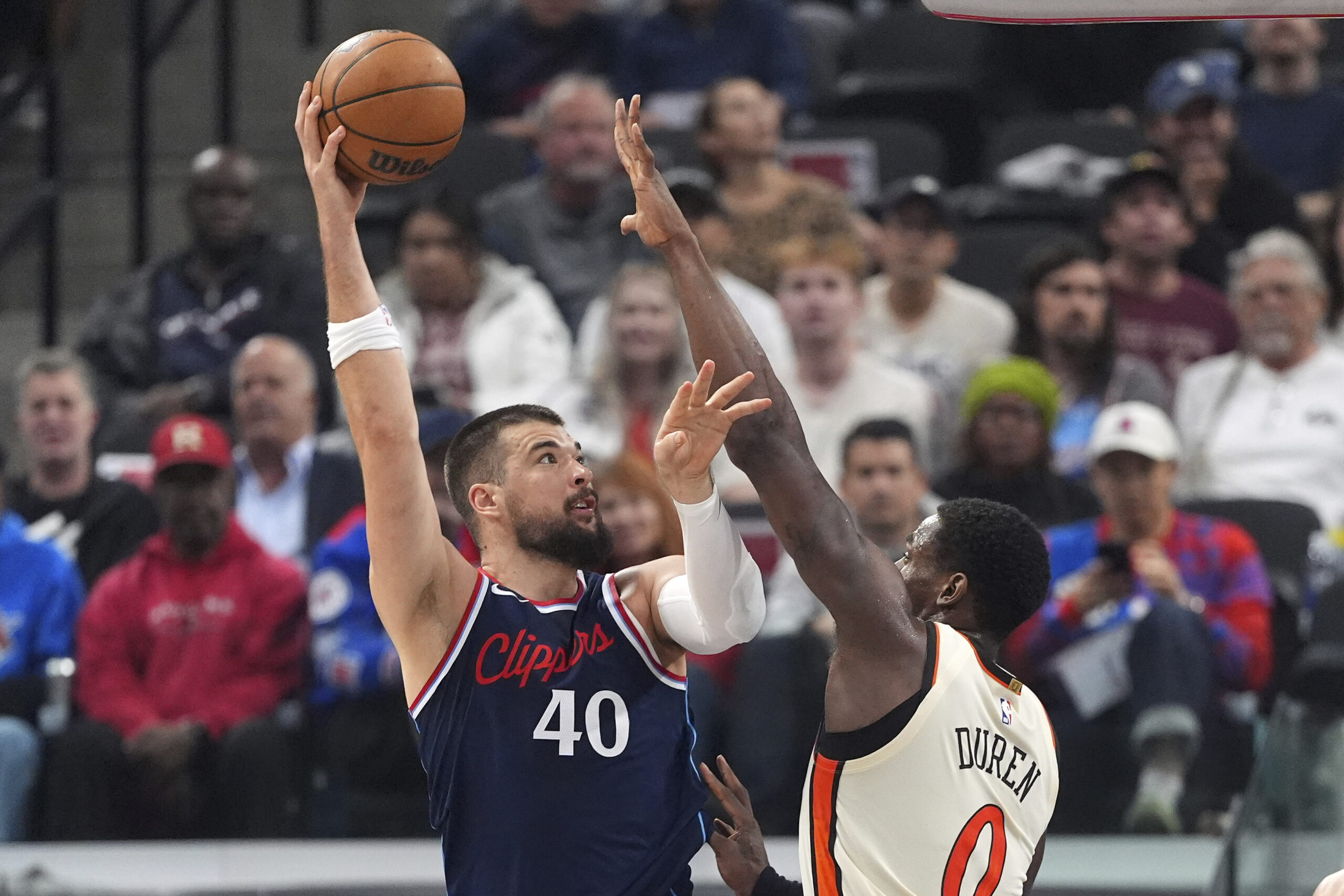 Clippers center Ivica Zubac, left, shoots as Detroit Pistons center...