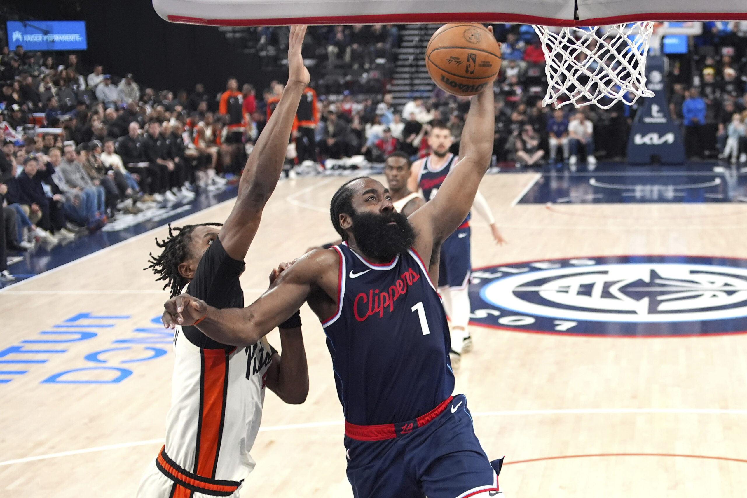 Clippers star James Harden, right, gets to the basket as...