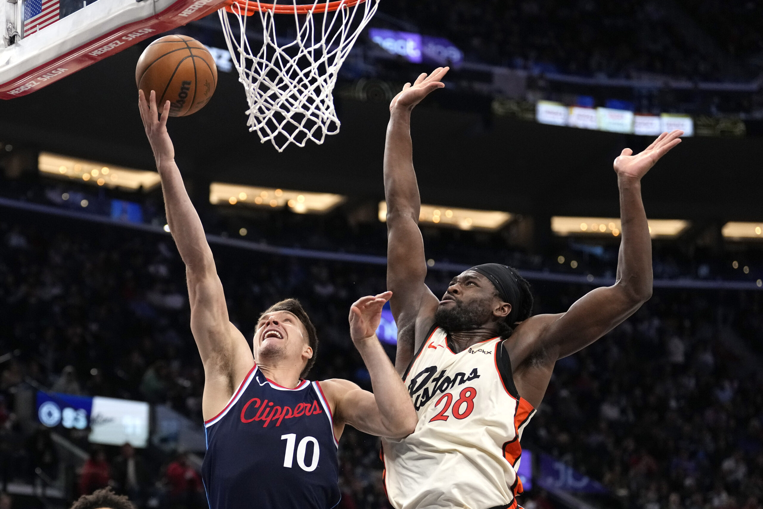 Clippers guard Bogdan Bogdanovic, left, shoots as Detroit Pistons center...