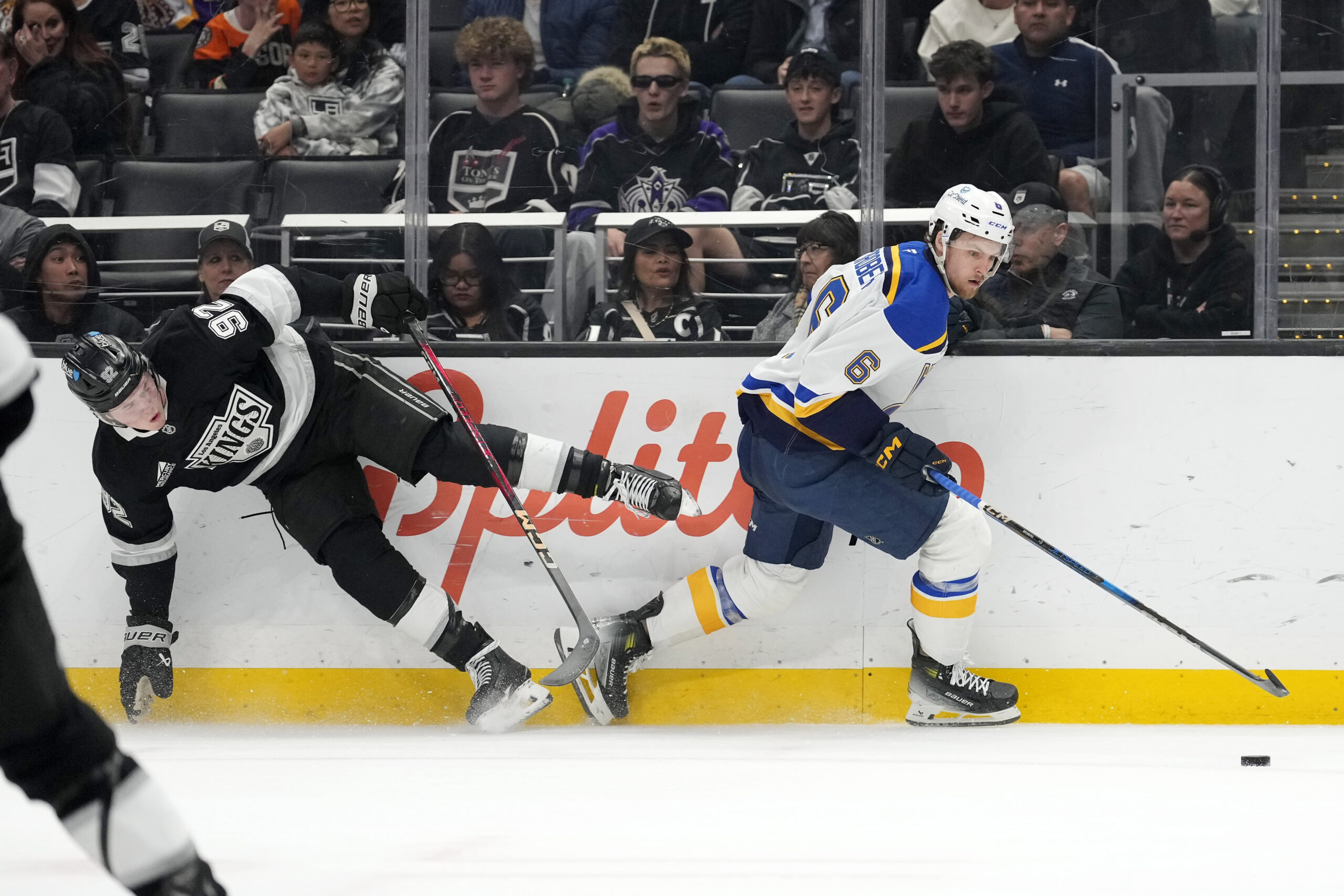 Kings defenseman Brandt Clarke, left, falls as he battles for...