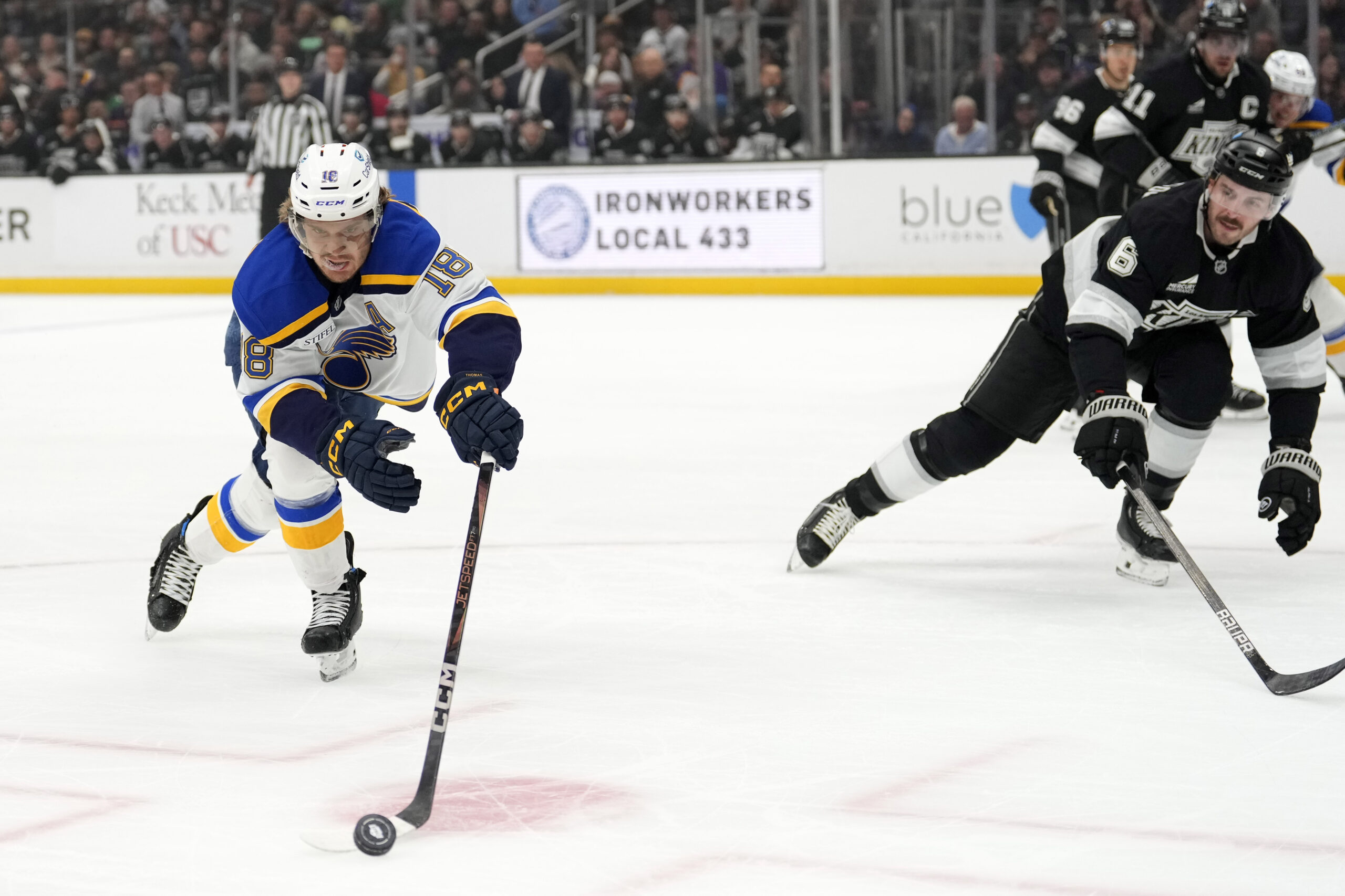 St. Louis Blues center Robert Thomas, left, takes the puck...