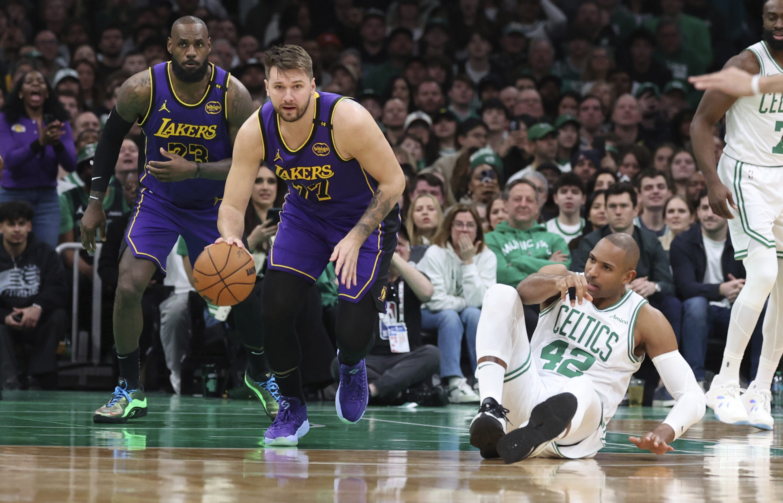 Lakers guard Luka Doncic (77), trailed by teammate forward LeBron...