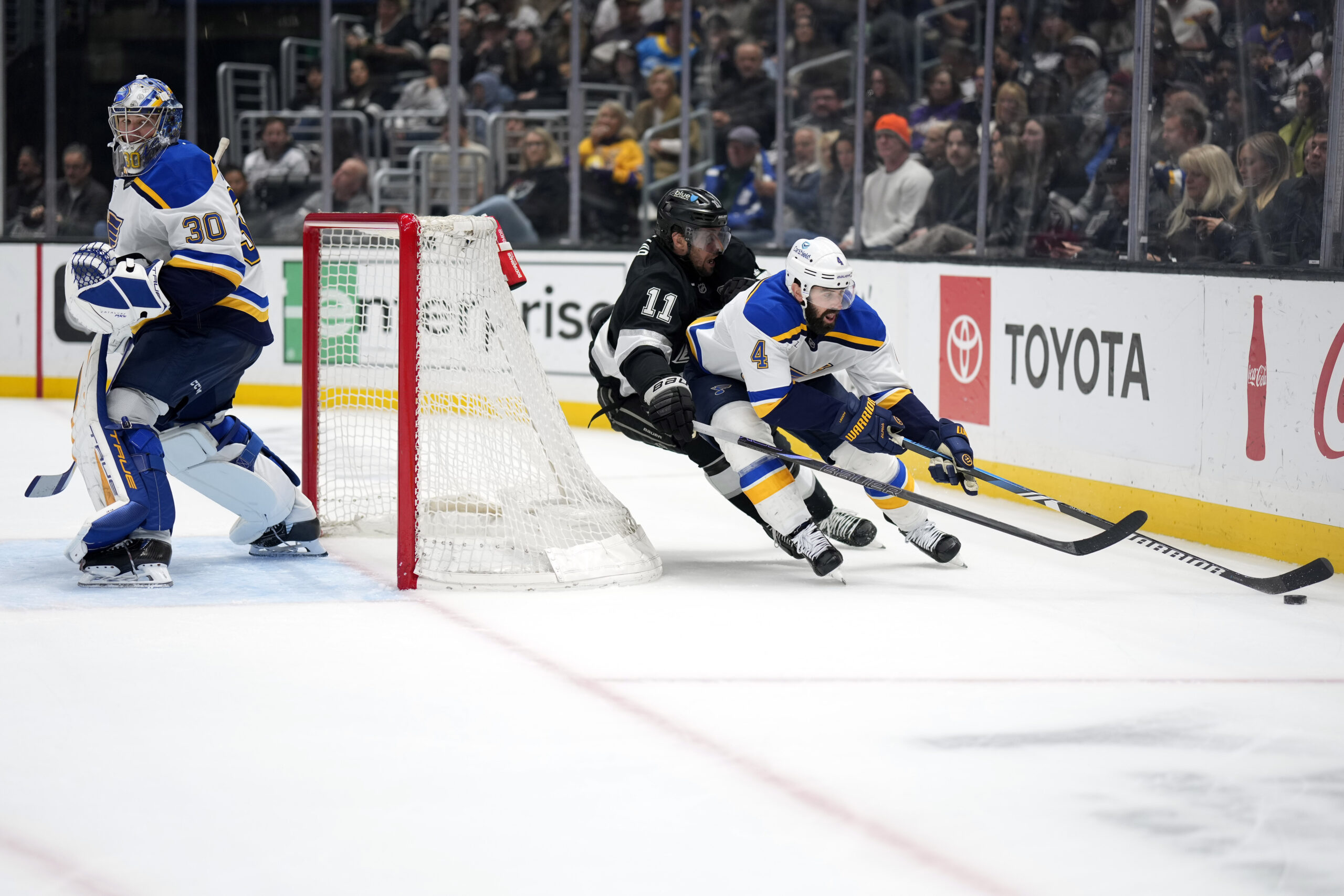 St. Louis Blues defenseman Nick Leddy, right, moves the puck...