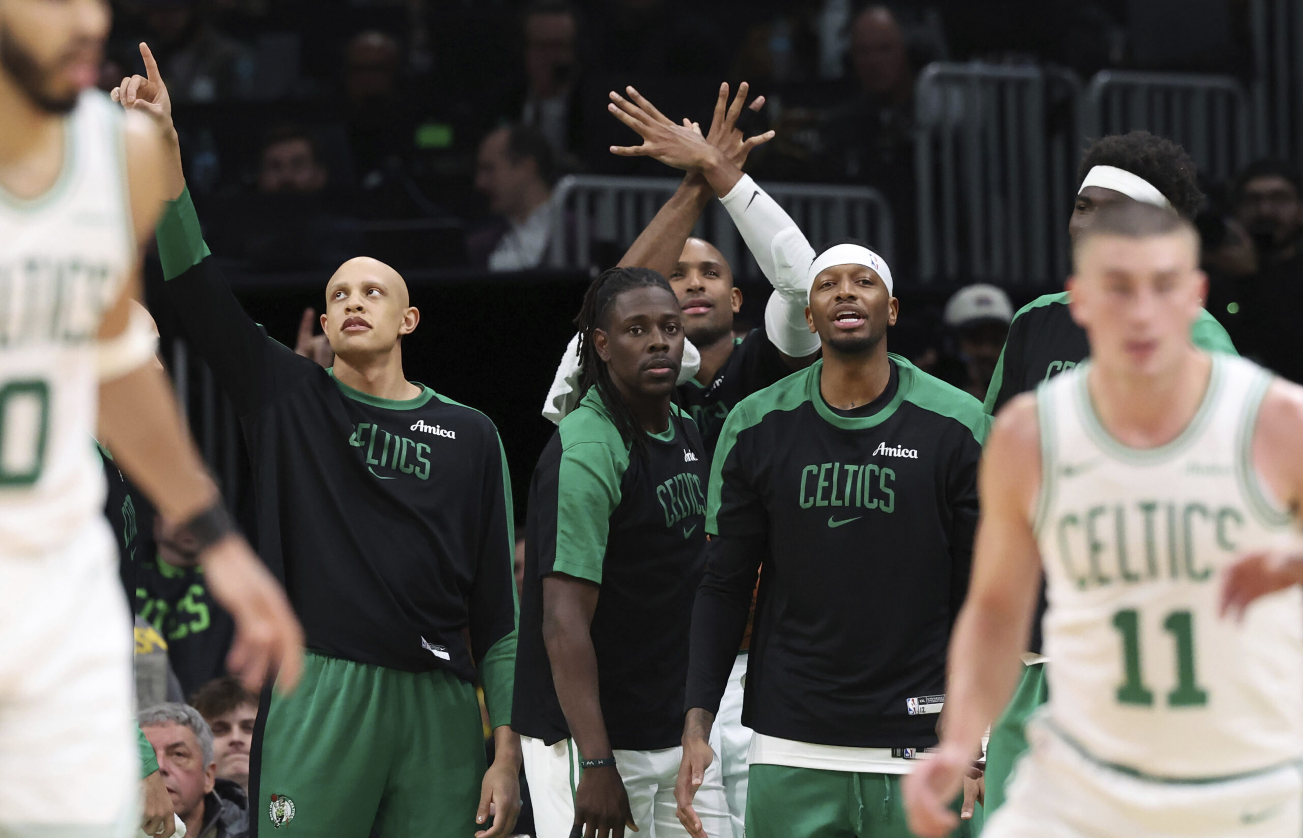 The Boston Celtics bench react after a 3-point basket during...