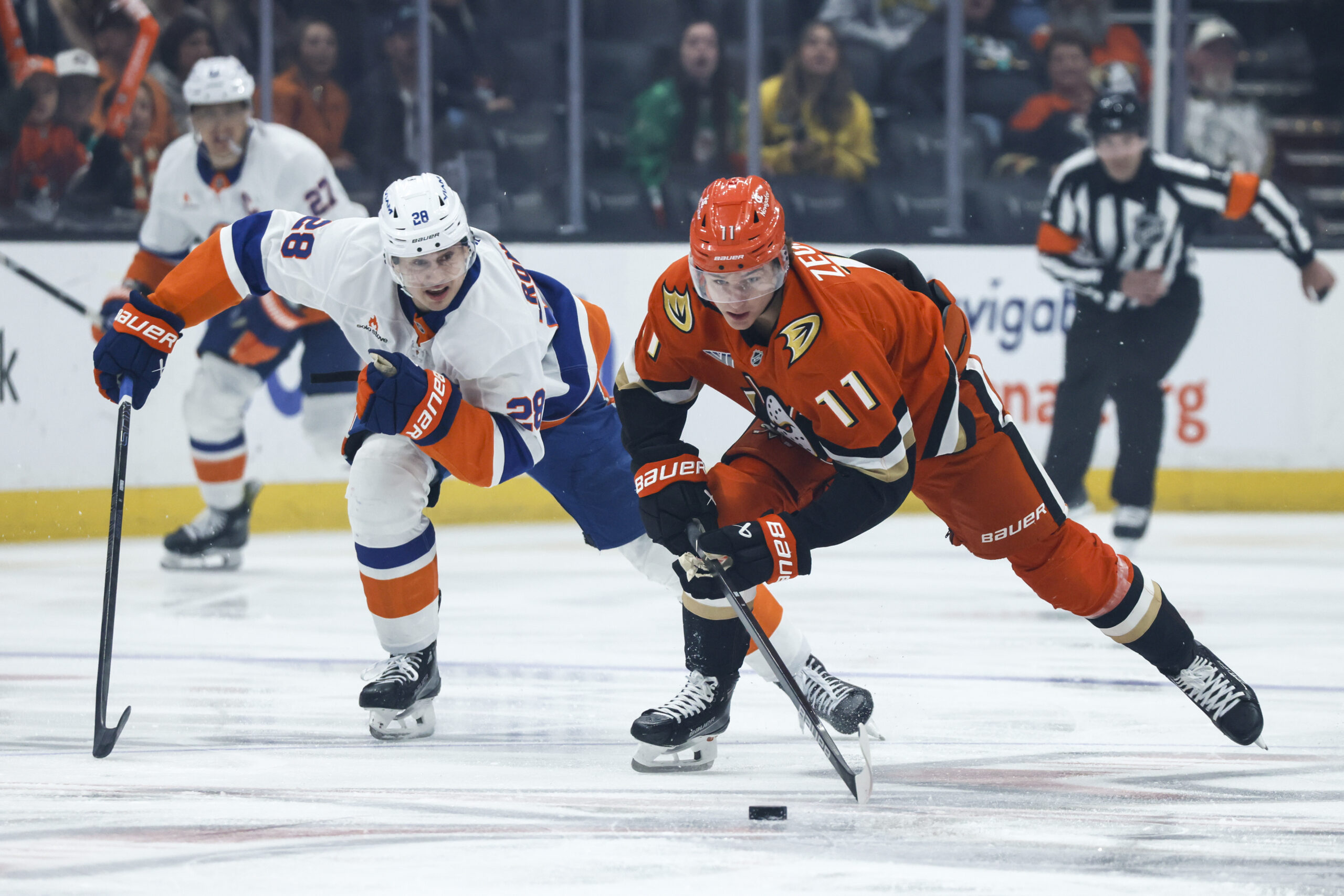 Ducks center Trevor Zegras, right, controls the puck away from...