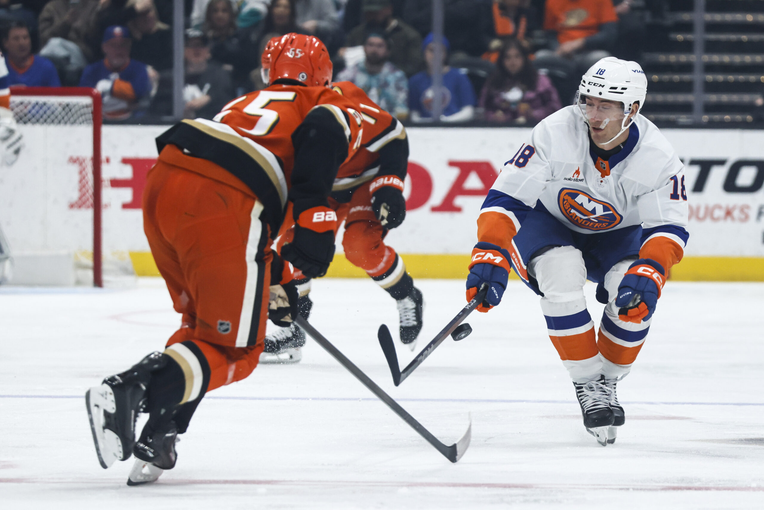 New York Islanders winger Pierre Engvall, right, controls the puck...