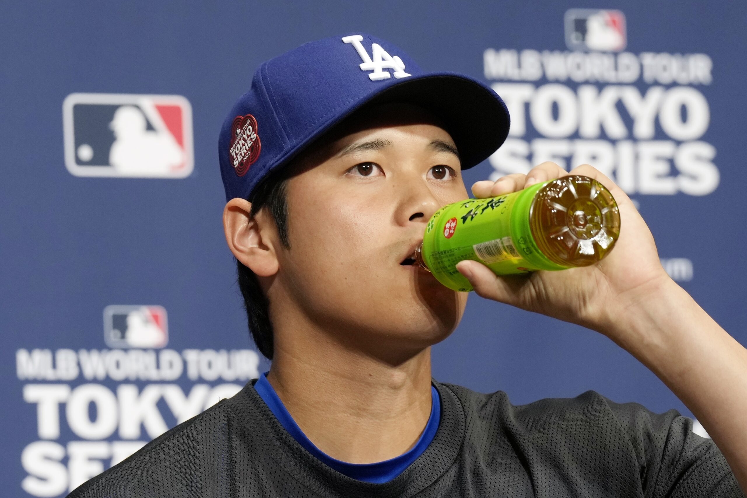 Dodgers star Shohei Ohtani drinks tea as he attends the...