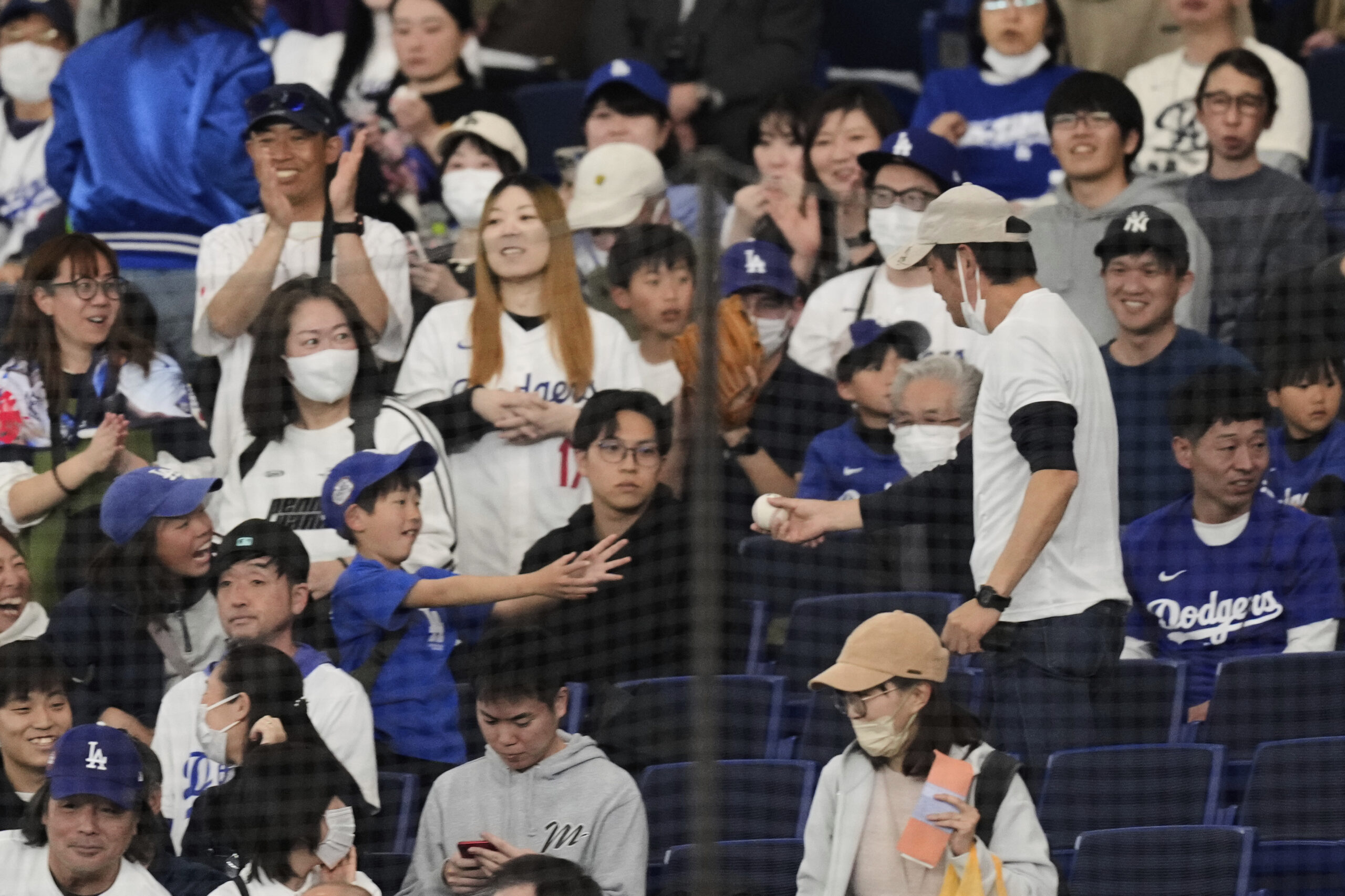 A man, center right, hands out a ball to a...