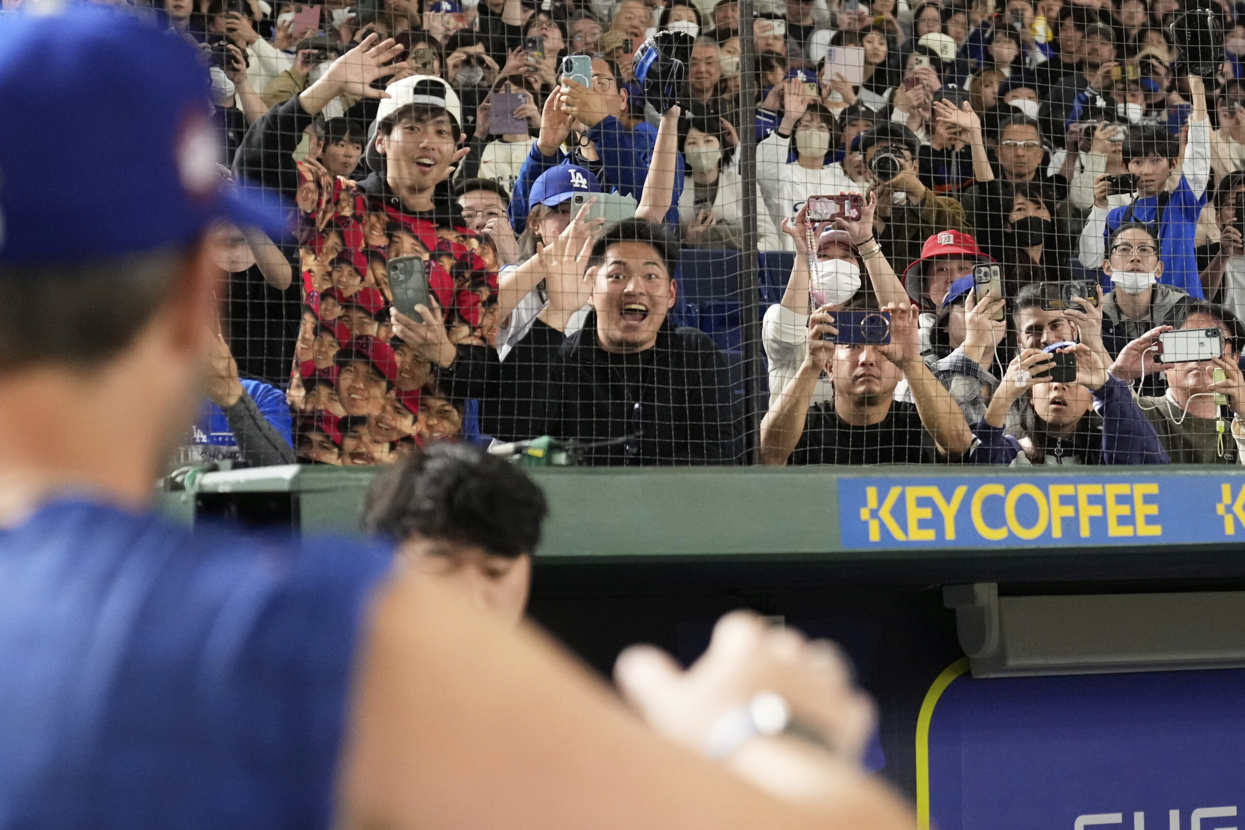 Baseball fans cheer as a Dodgers player waves during a...