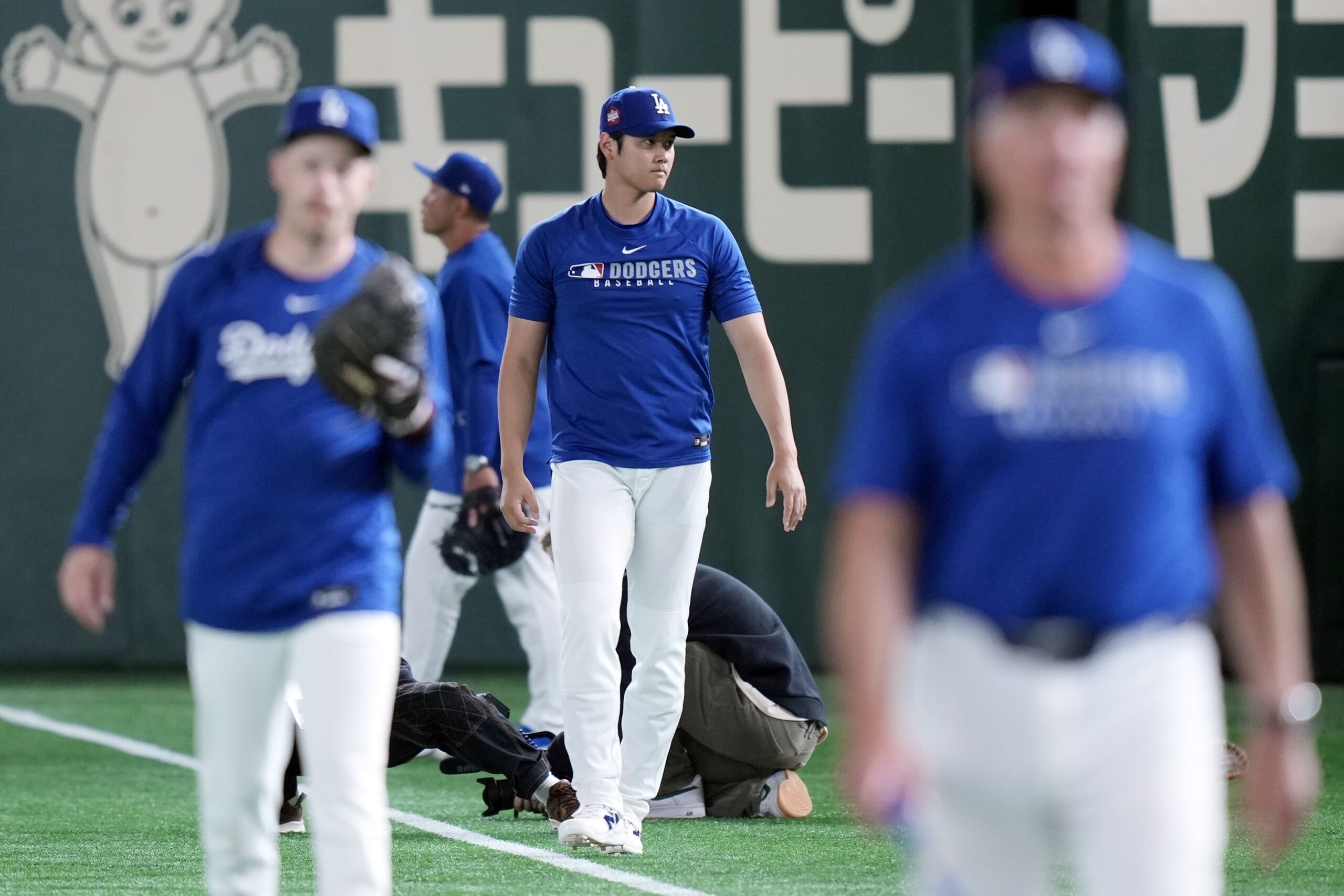 Dodgers star Shohei Ohtani, center, warms up during the official...