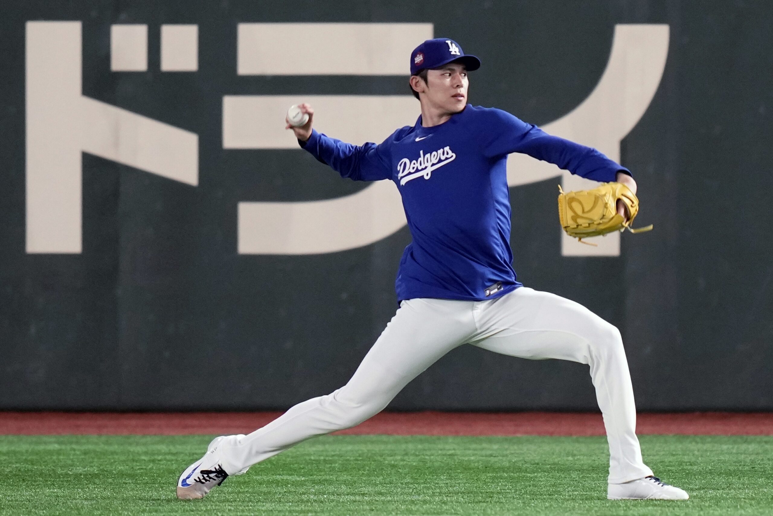 Dodgers pitcher Roki Sasaki warms up during the official training,...