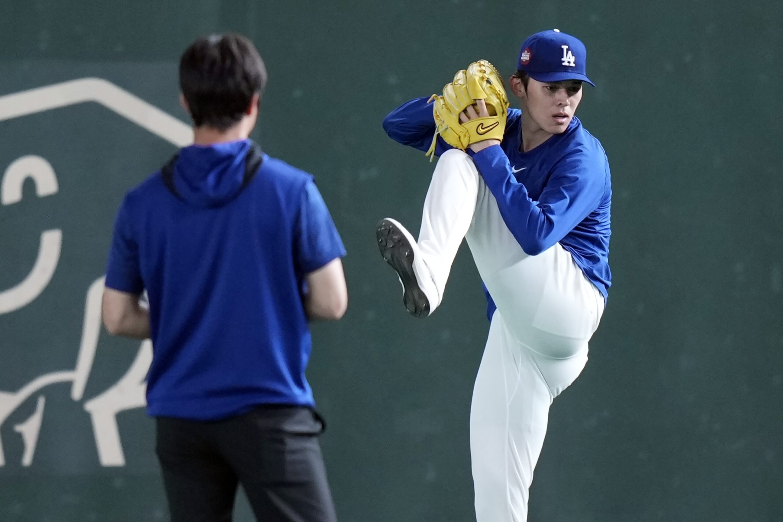 Dodgers pitcher Roki Sasaki warms up during the official training,...