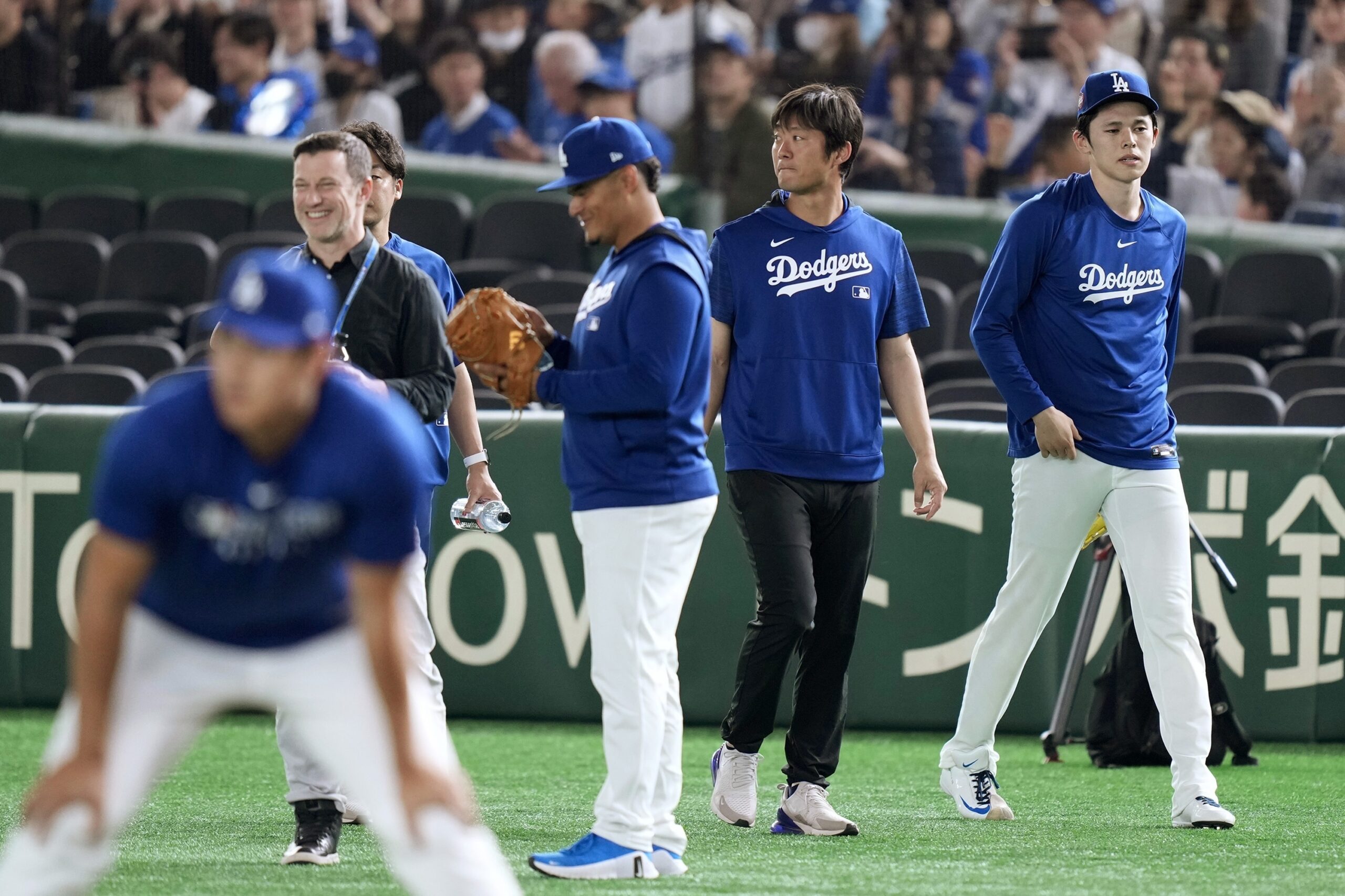 Dodgers pitcher Roki Sasaki, right, walks on the field during...