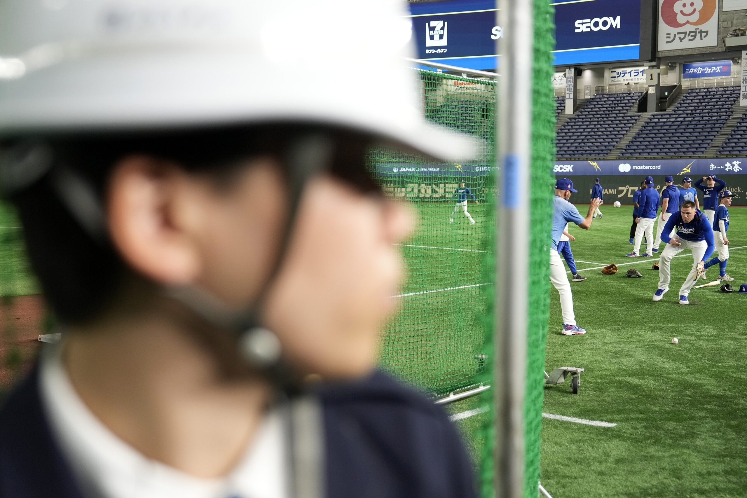 Dodgers players warm up as a security guard stands guard...