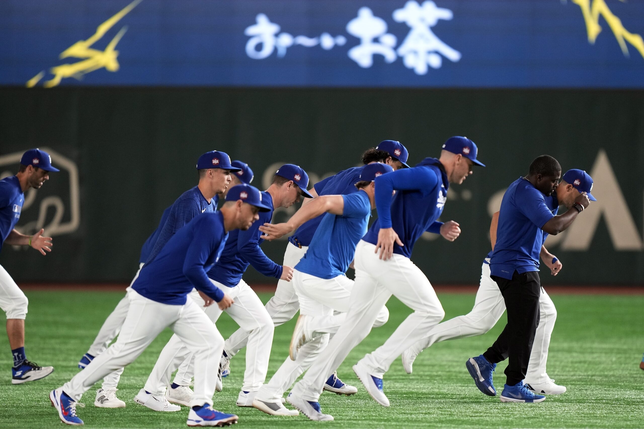 Dodgers players warm up during the official training Friday, March...