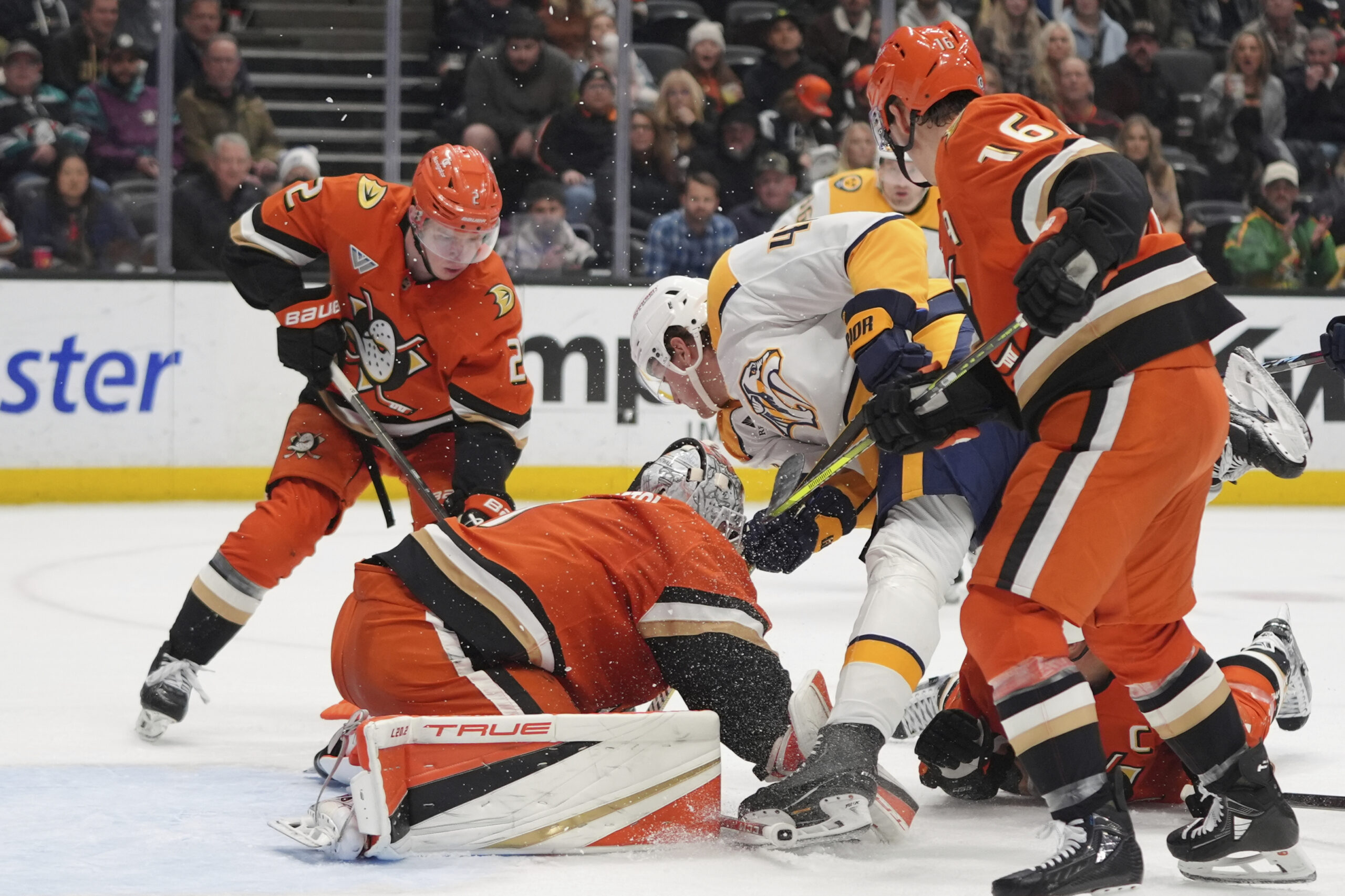 Ducks goaltender Lukas Dostal, front left, stops a shot by...