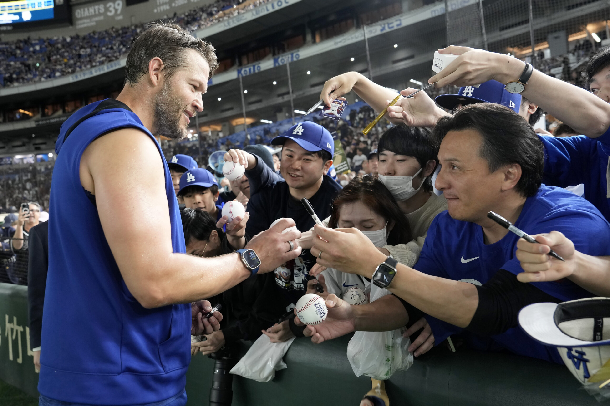 Dodgers pitcher Clayton Kershaw, left, signs autographs for fans before...