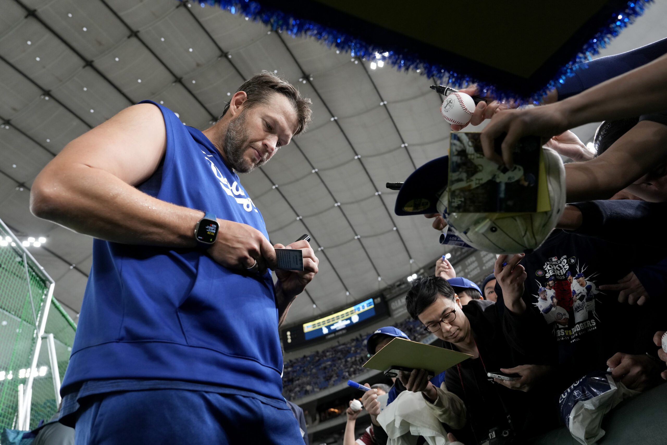 Dodgers pitcher Clayton Kershaw, left, signs autographs for fans before...