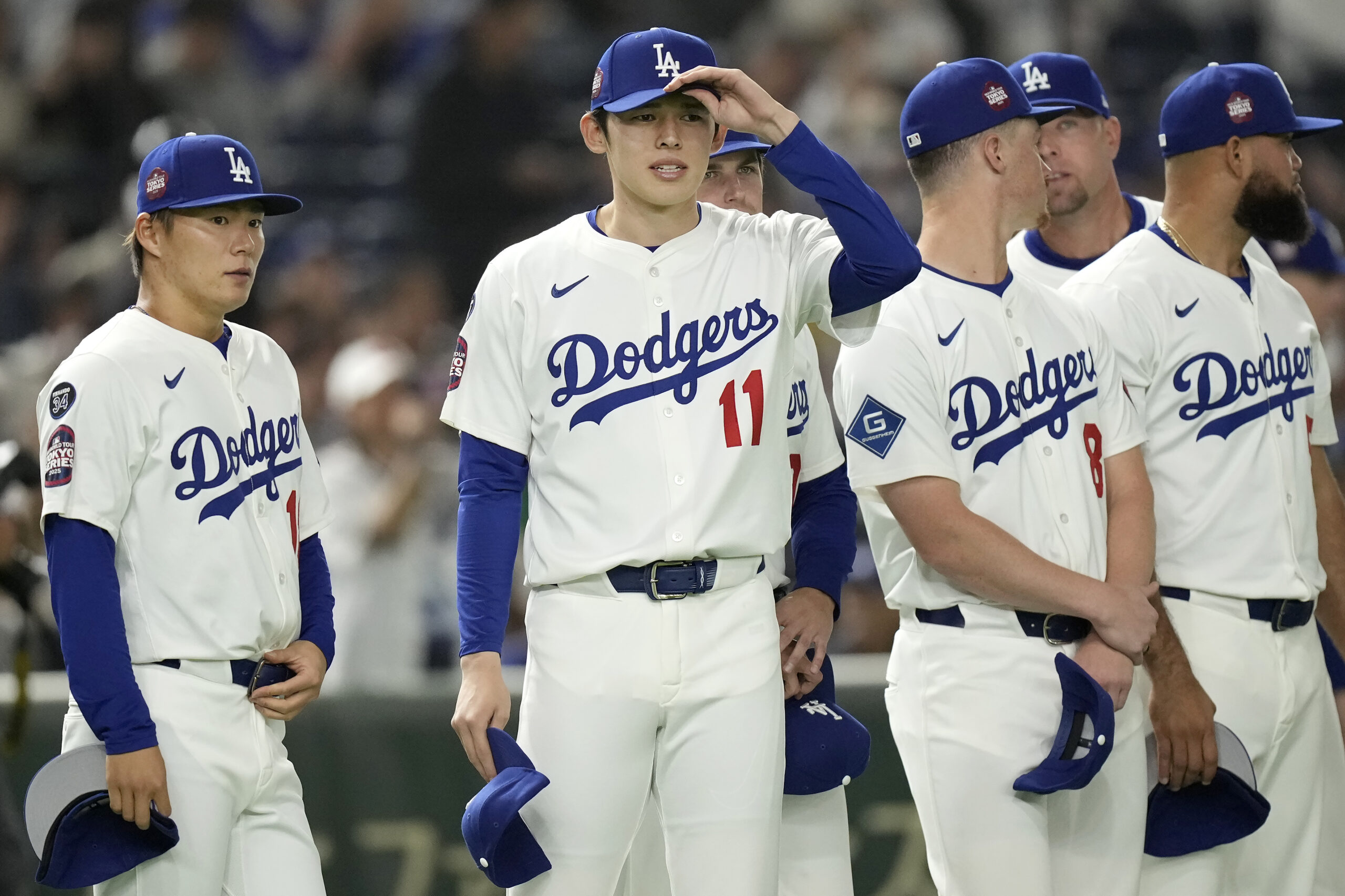 Dodgers pitchers Yoshinobu Yamamoto, left, and Roki Sasaki (11) stand...