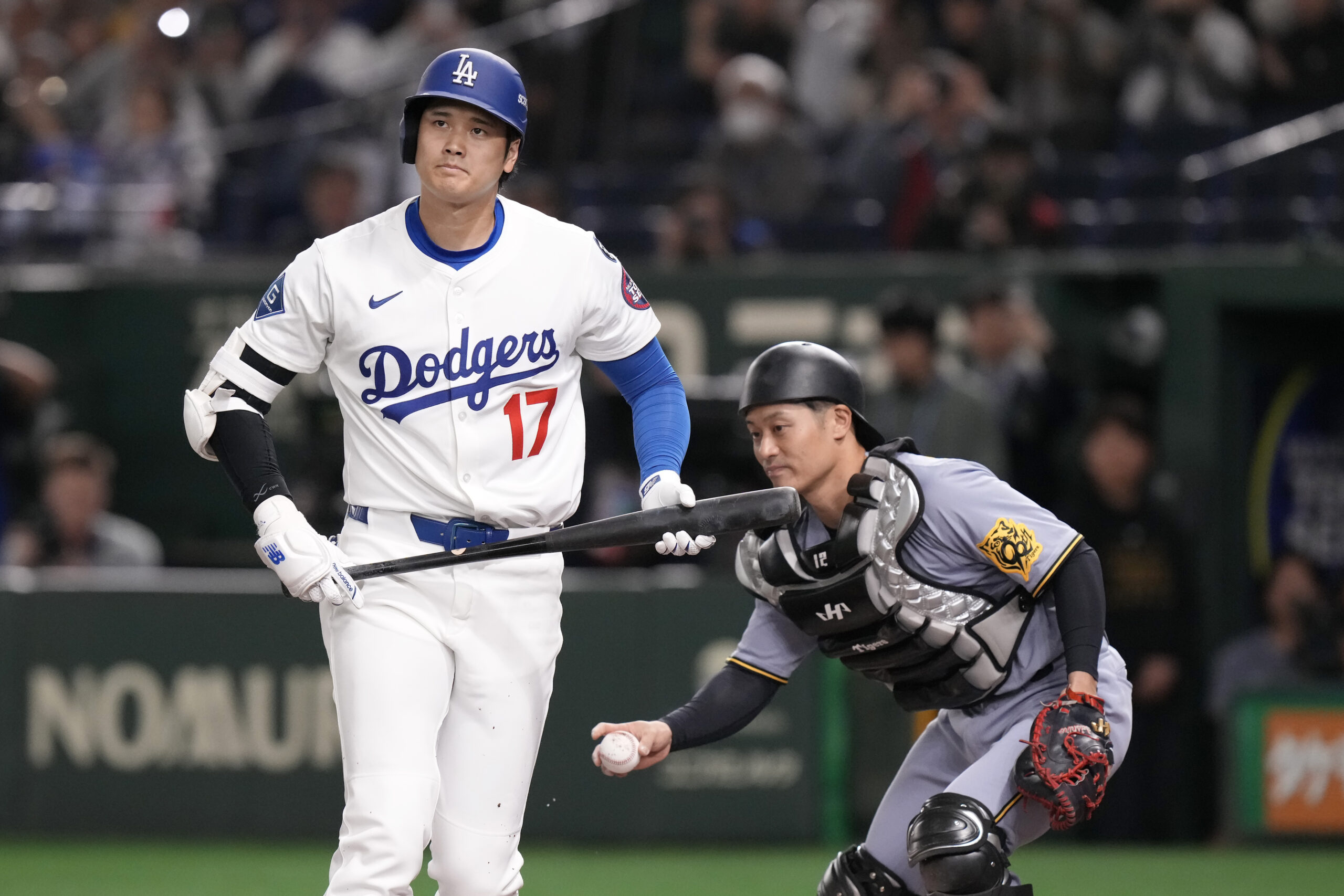 Dodgers star Shohei Ohtani reacts after striking out next to...