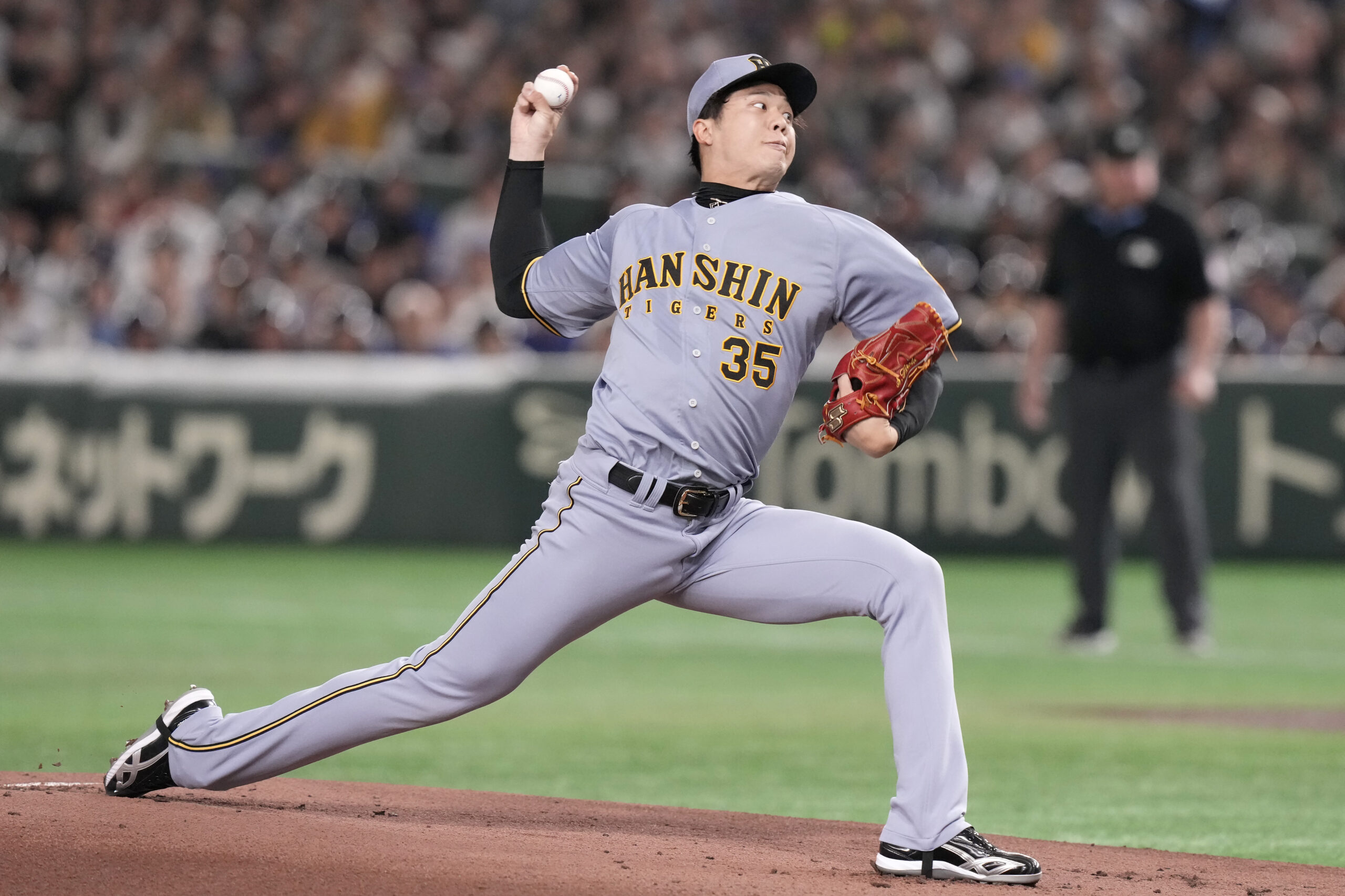 Hanshin Tigers pitcher Hiroto Saiki works against the Dodgers during...