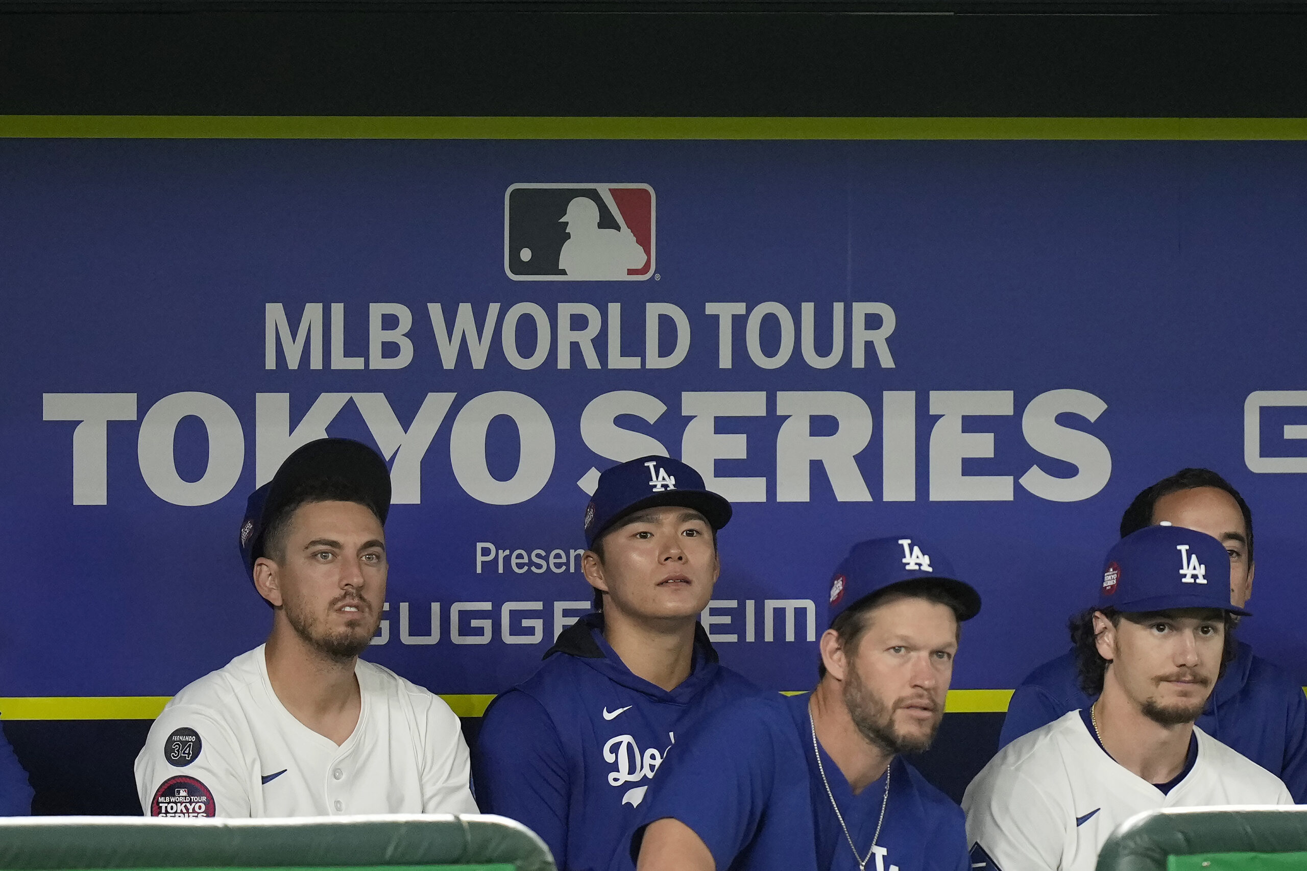 Dodgers players watch from the dugout during the first inning...