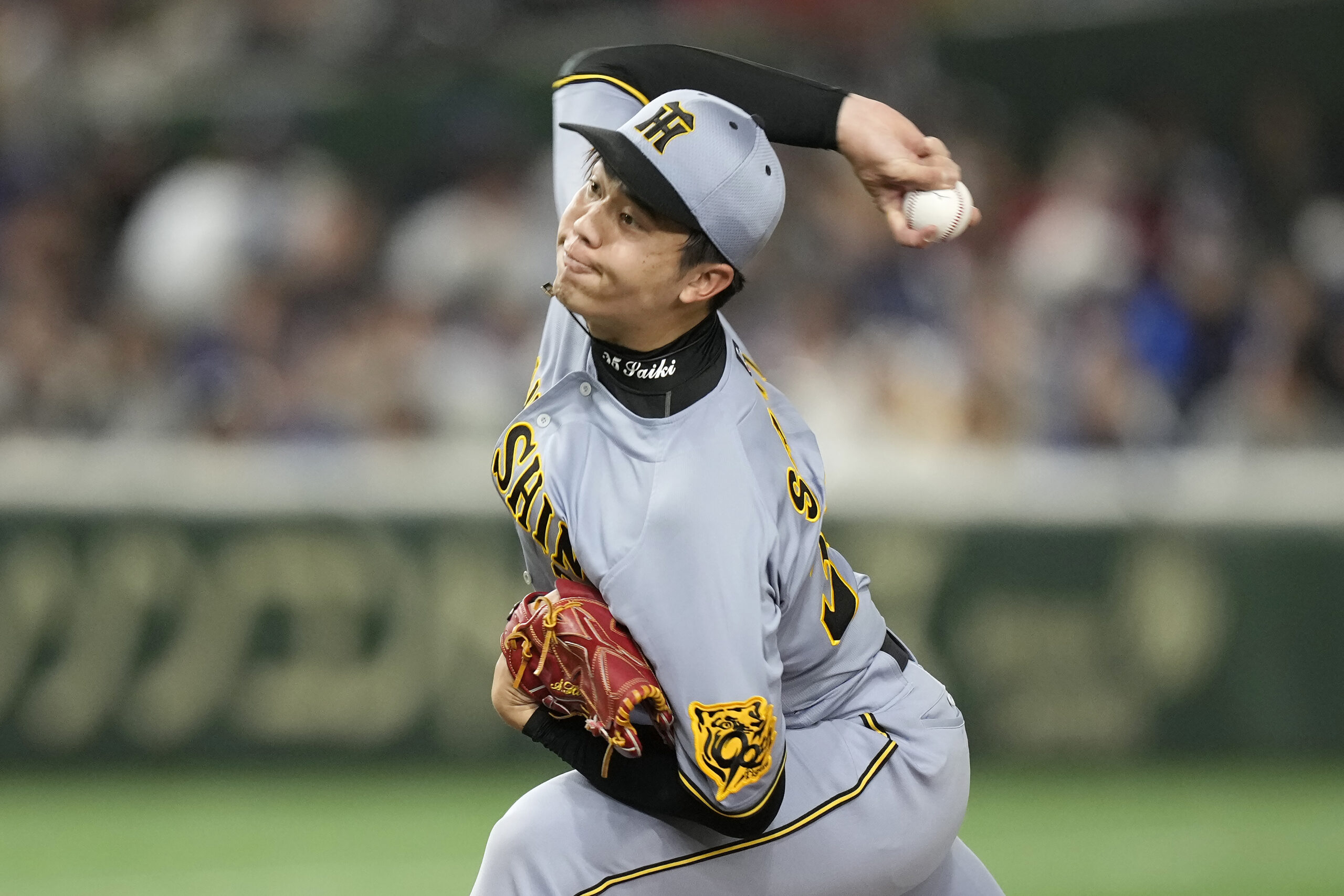 Hanshin Tigers pitcher Hiroto Saiki works against the Dodgers during...