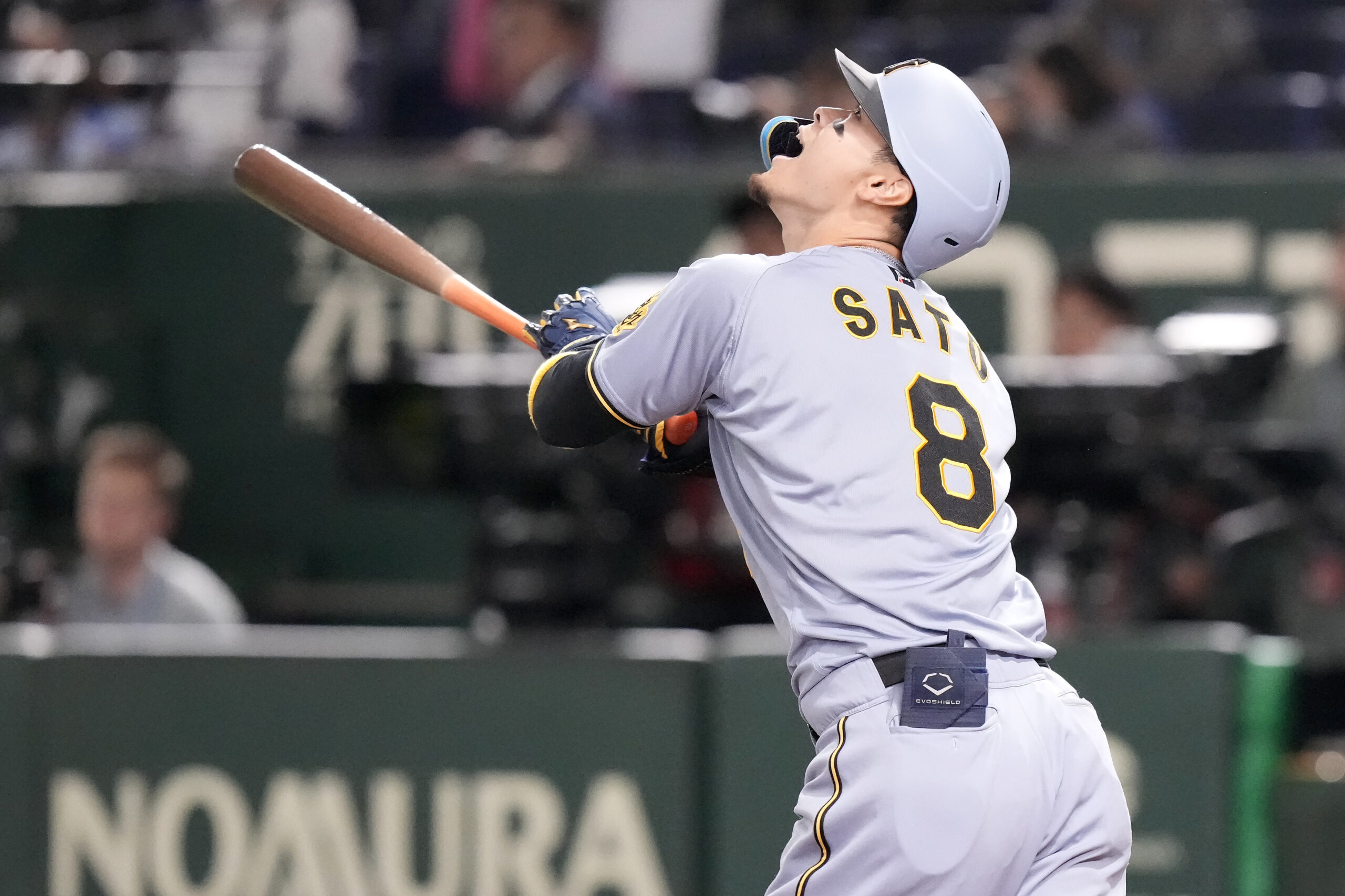 The Hanshin Tigers’ Teruaki Sato reacts as he fliles out...