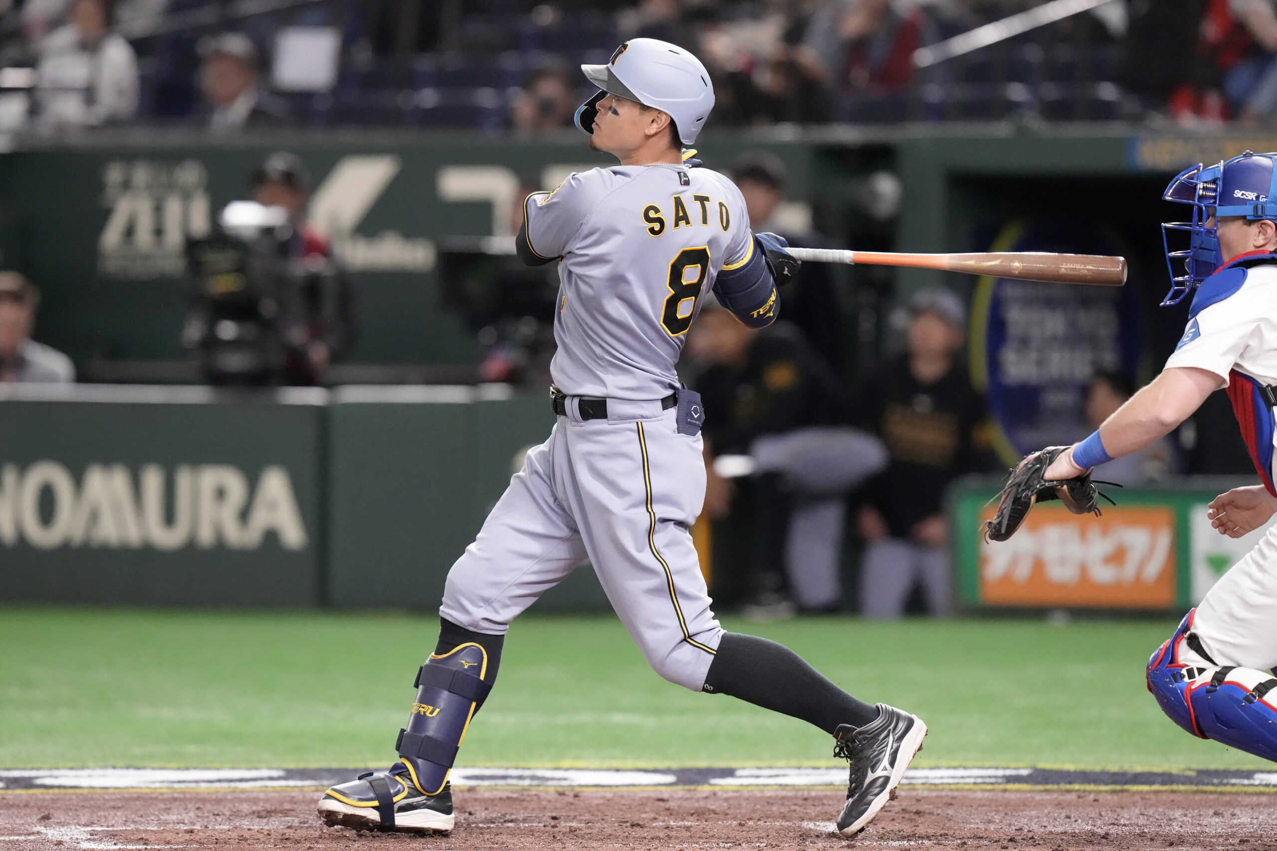 The Hanshin Tigers’ Teruaki Sato hits a three-run home run...