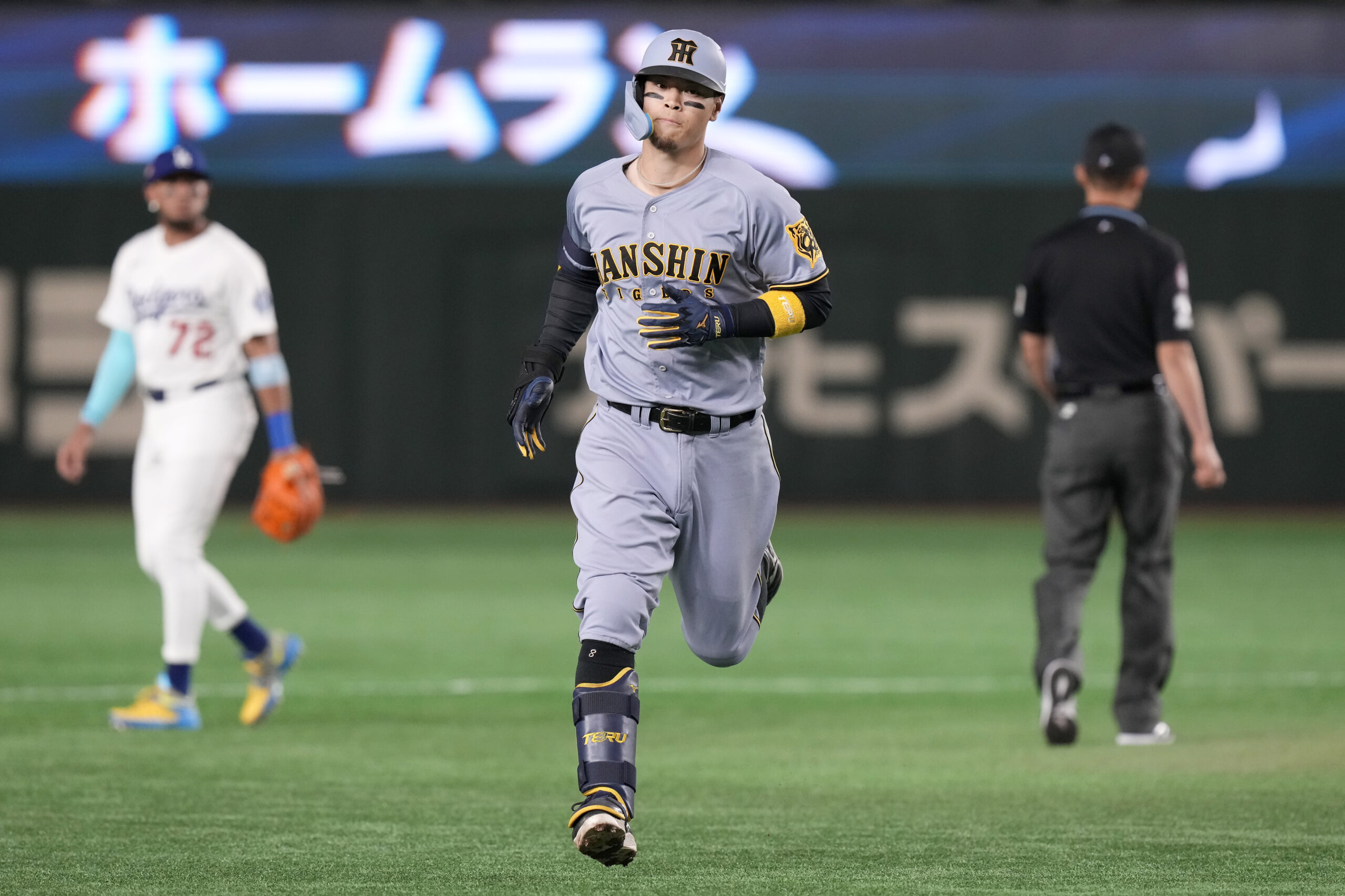 The Hanshin Tigers’ Teruaki Sato runs the bases after hitting...