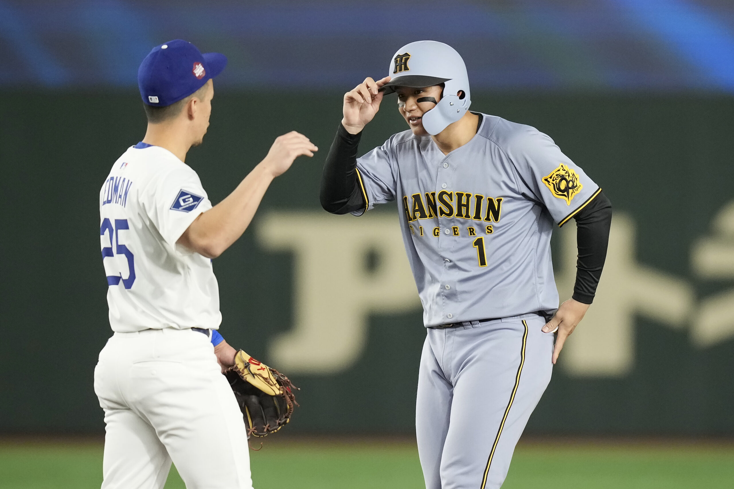 The Hanshin Tigers’ Shota Morishita (1) gestures after hitting a...