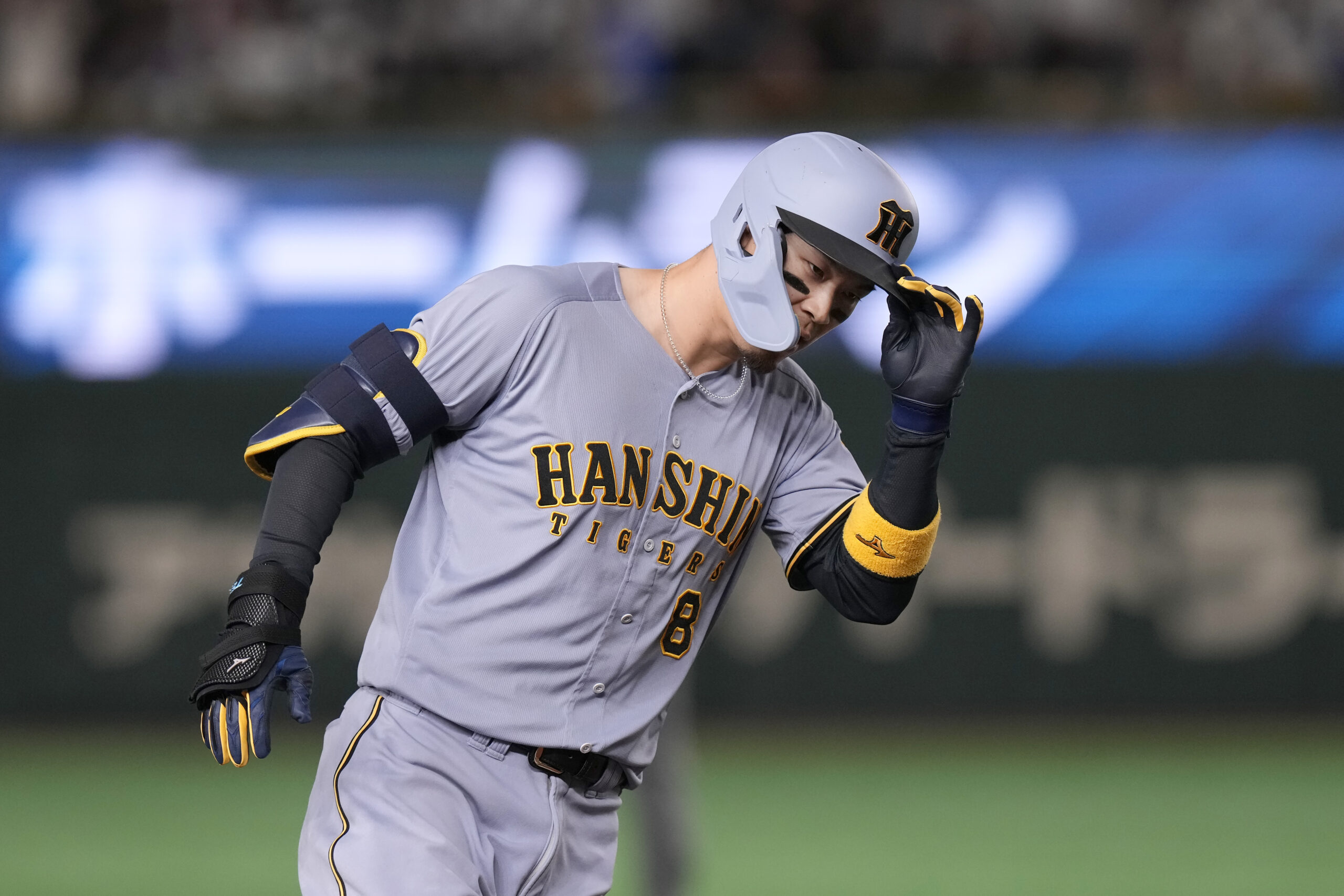 The Hanshin Tigers’ Teruaki Sato gestures after hitting a three-run...