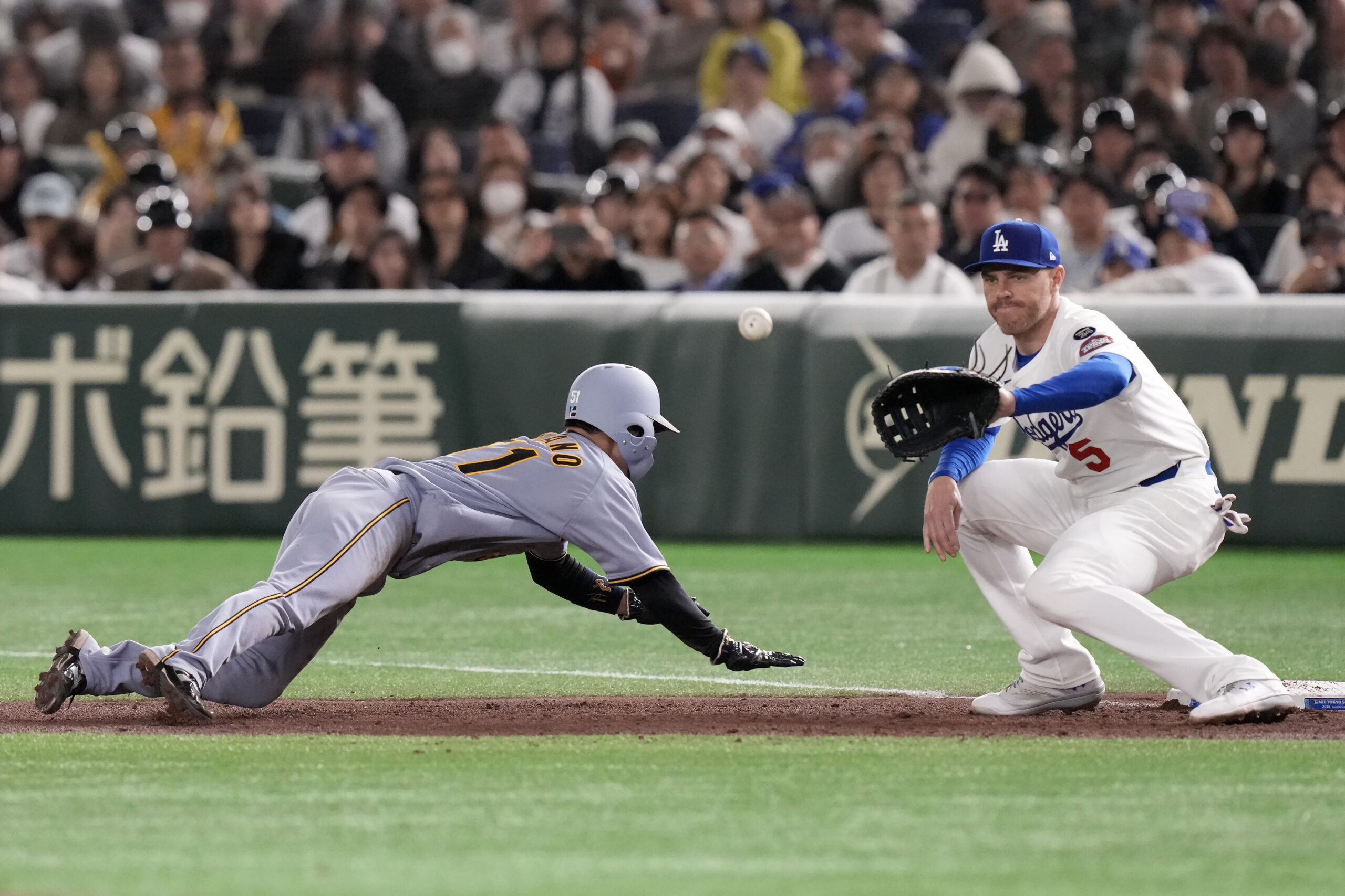 The Hanshin Tigers’ Takumu Nakano, left, dives back to first...