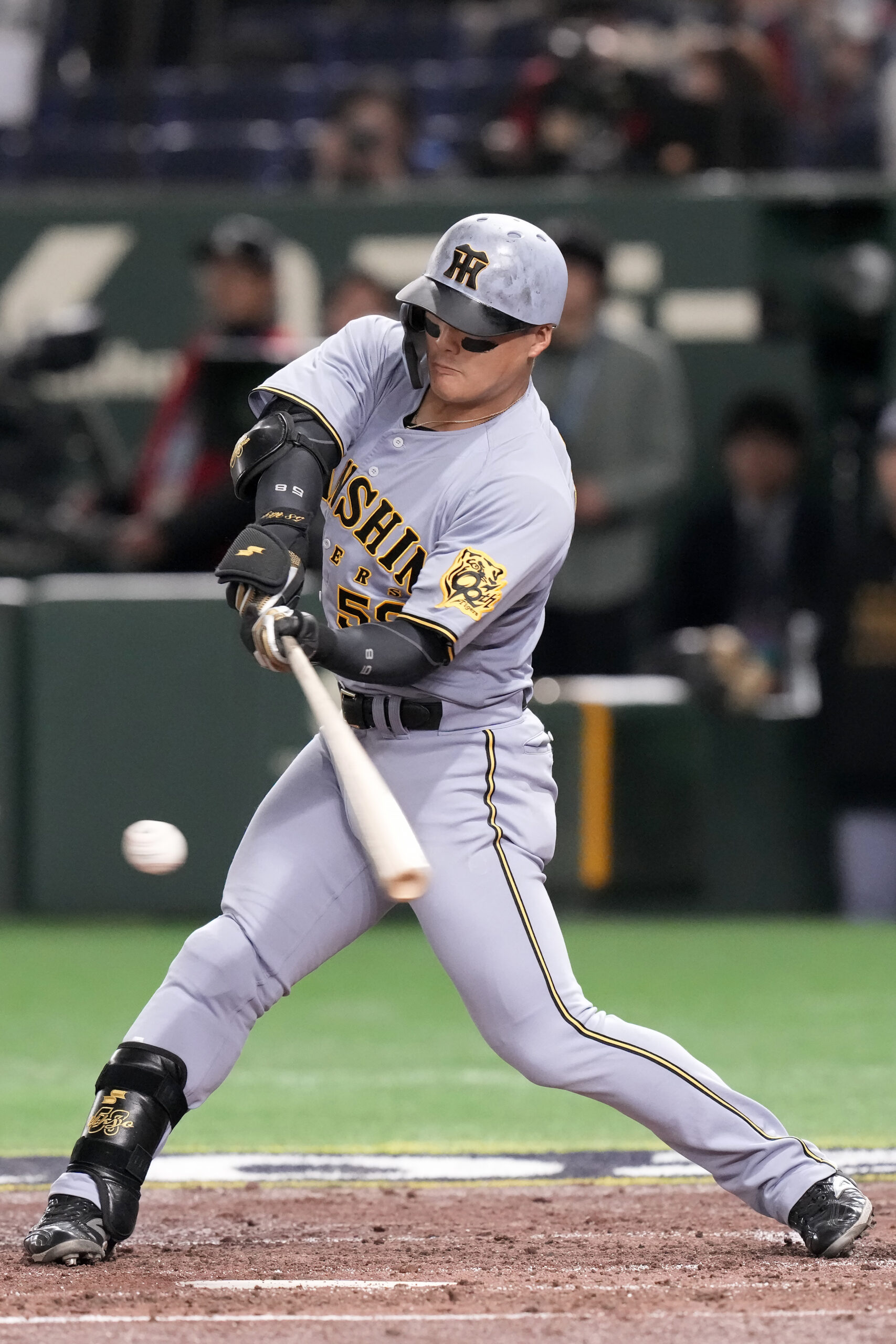 The Hanshin Tigers’ Ukyo Maegawa swings at a pitch against...