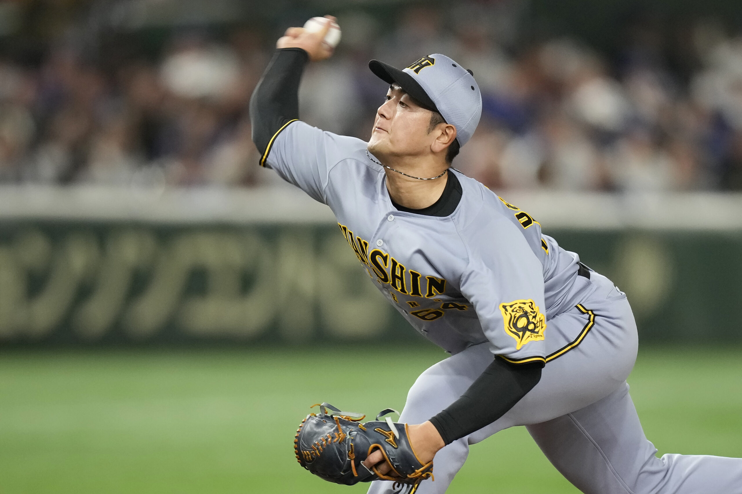 Hanshin Tigers pitcher Hidetaka Okadome works against the Dodgers during...