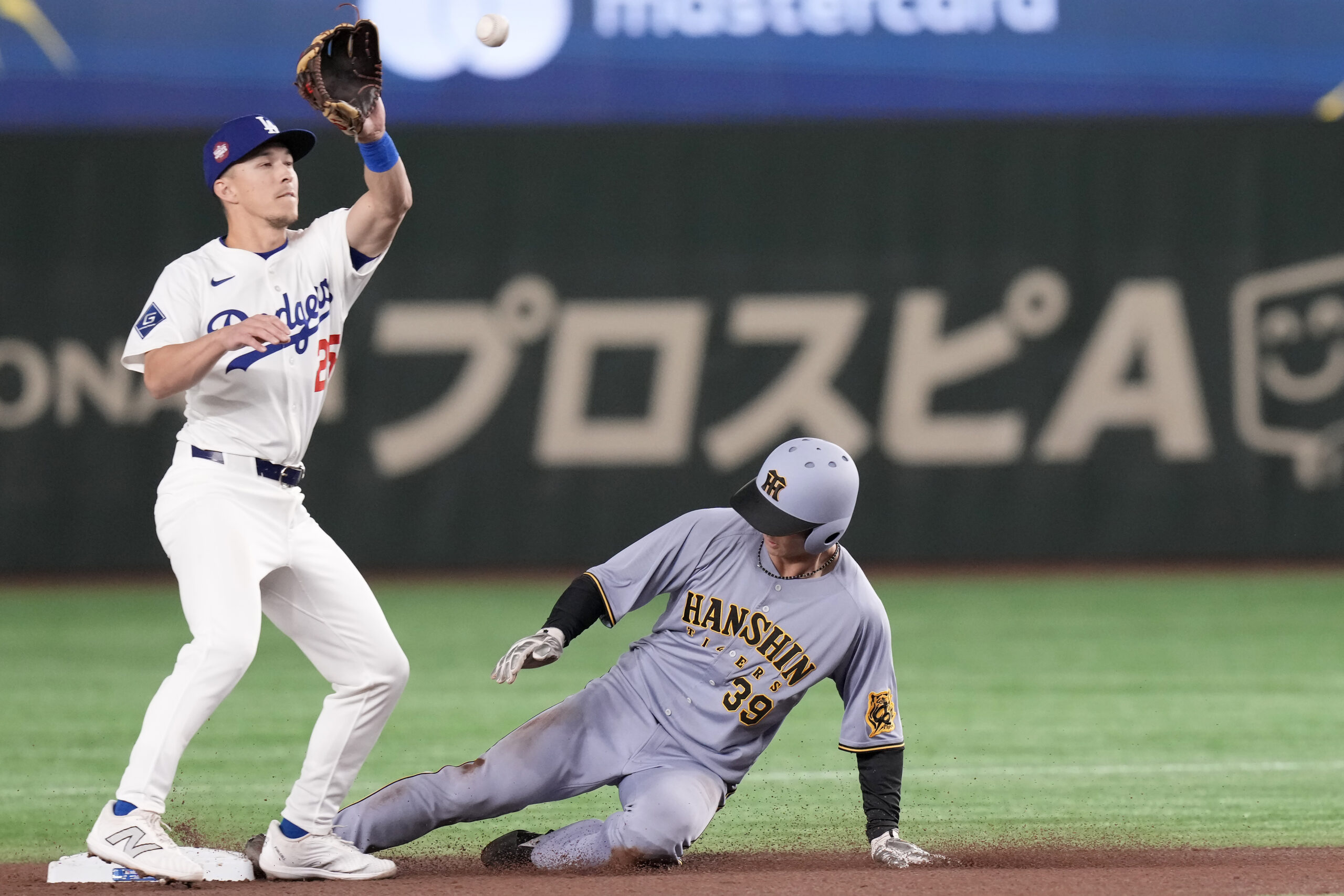 The Hanshin Tigers’ Yuki Sakaeda steals second base in front...