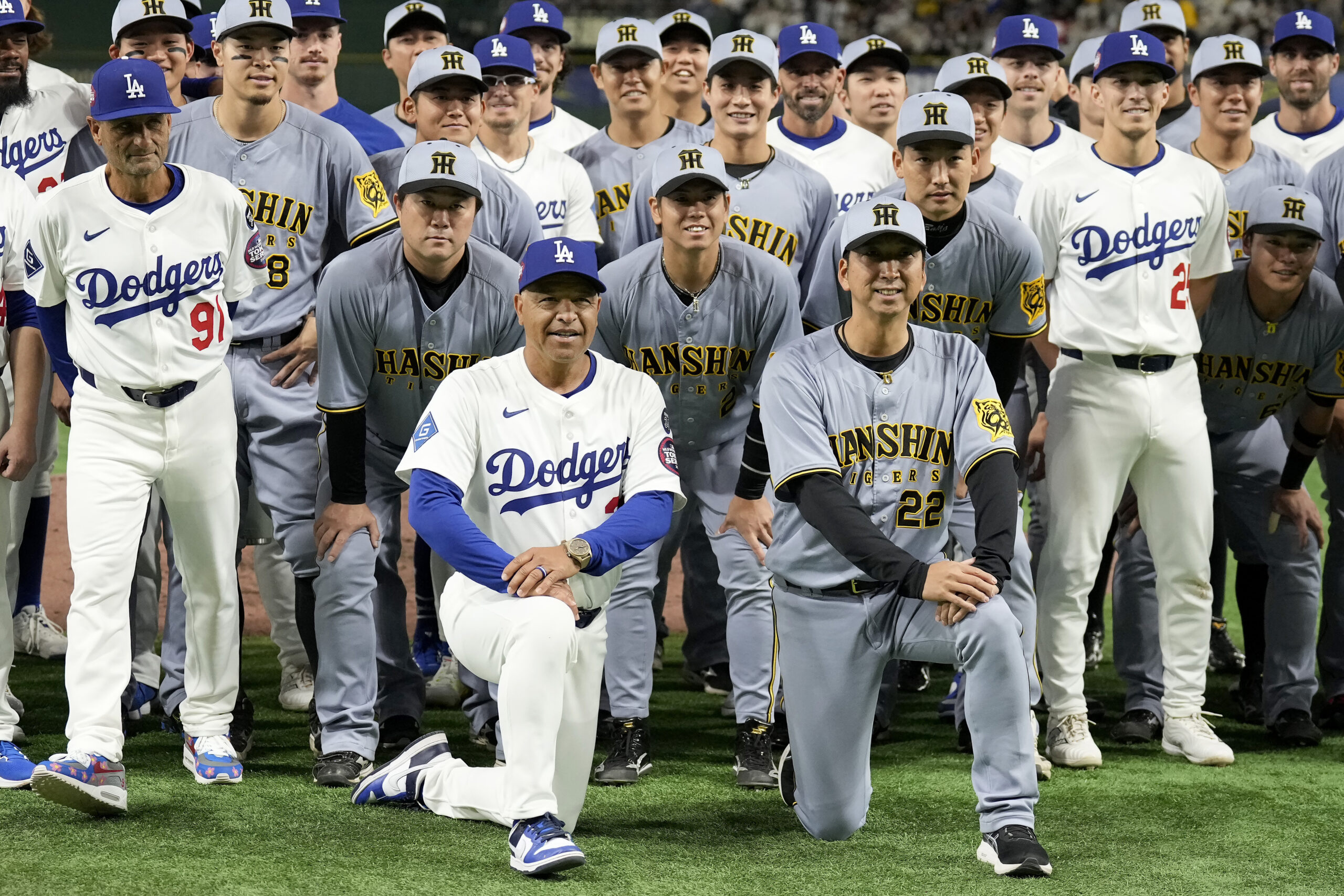 Dodgers manager Dave Roberts, foreground left, and Hanshin Tigers manager...