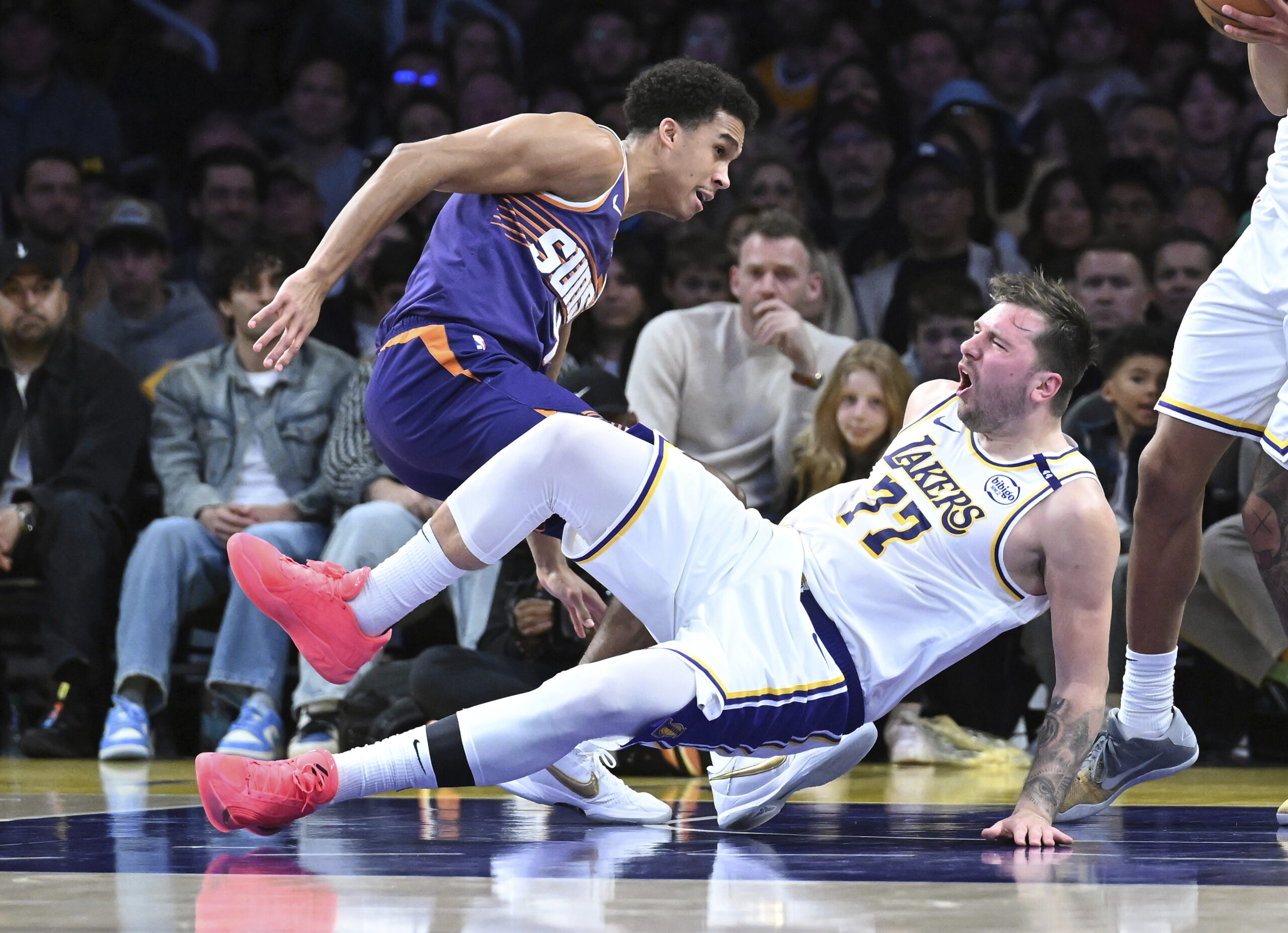 Lakers guard Luka Doncic (77) falls to the floor after...