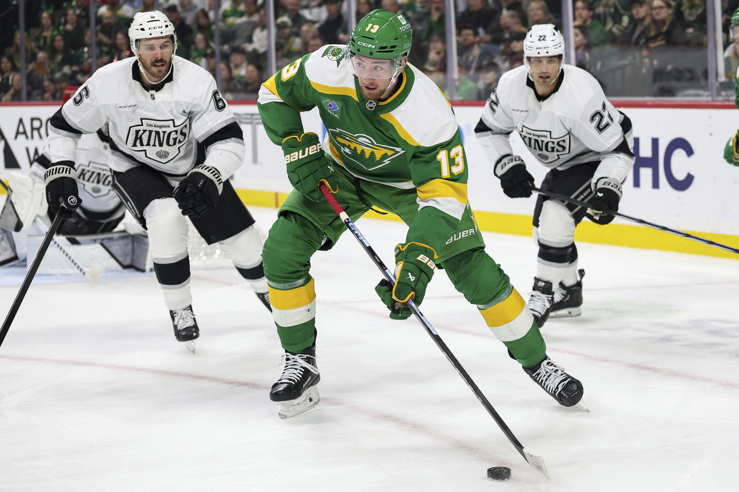 Minnesota Wild center Yakov Trenin, center, skates with the puck...