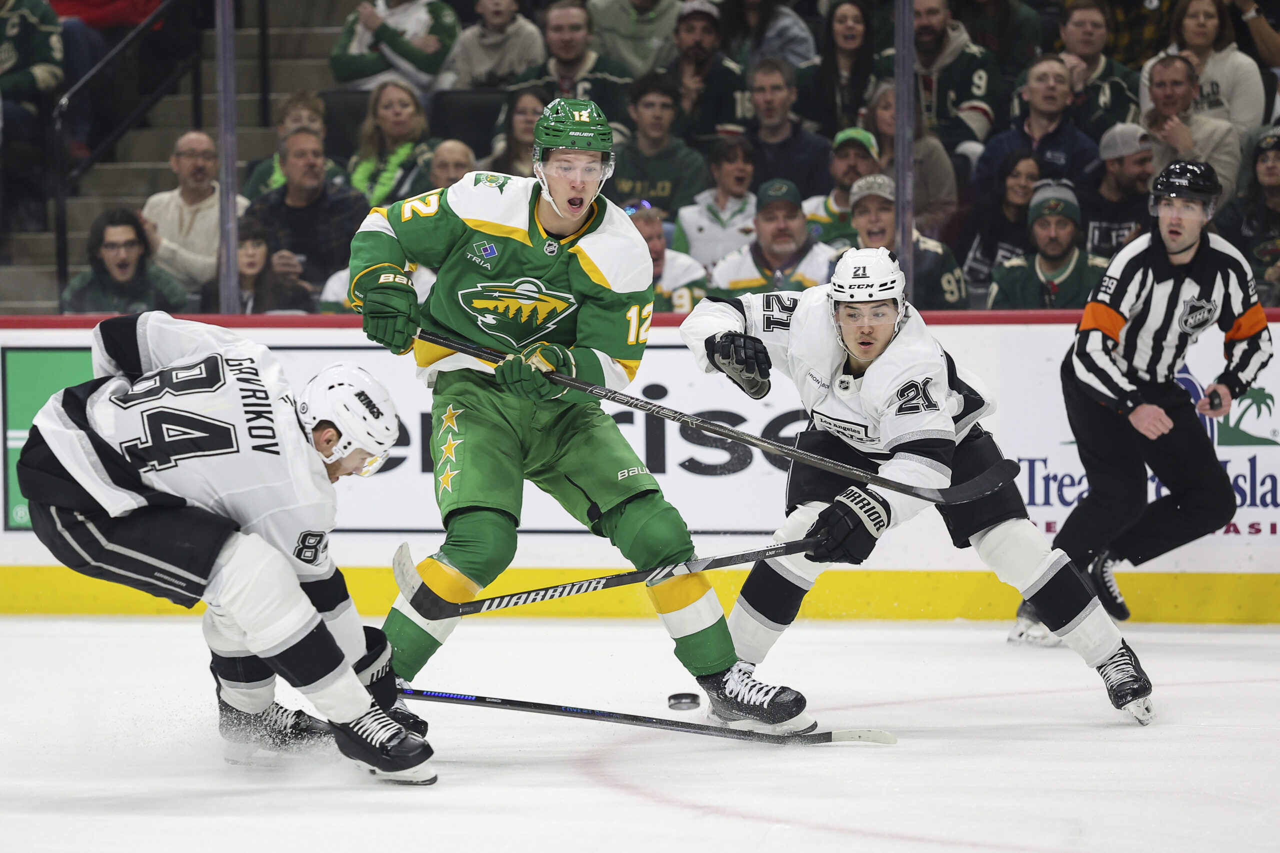 Minnesota Wild left wing Matt Boldy, center, passes the puck...