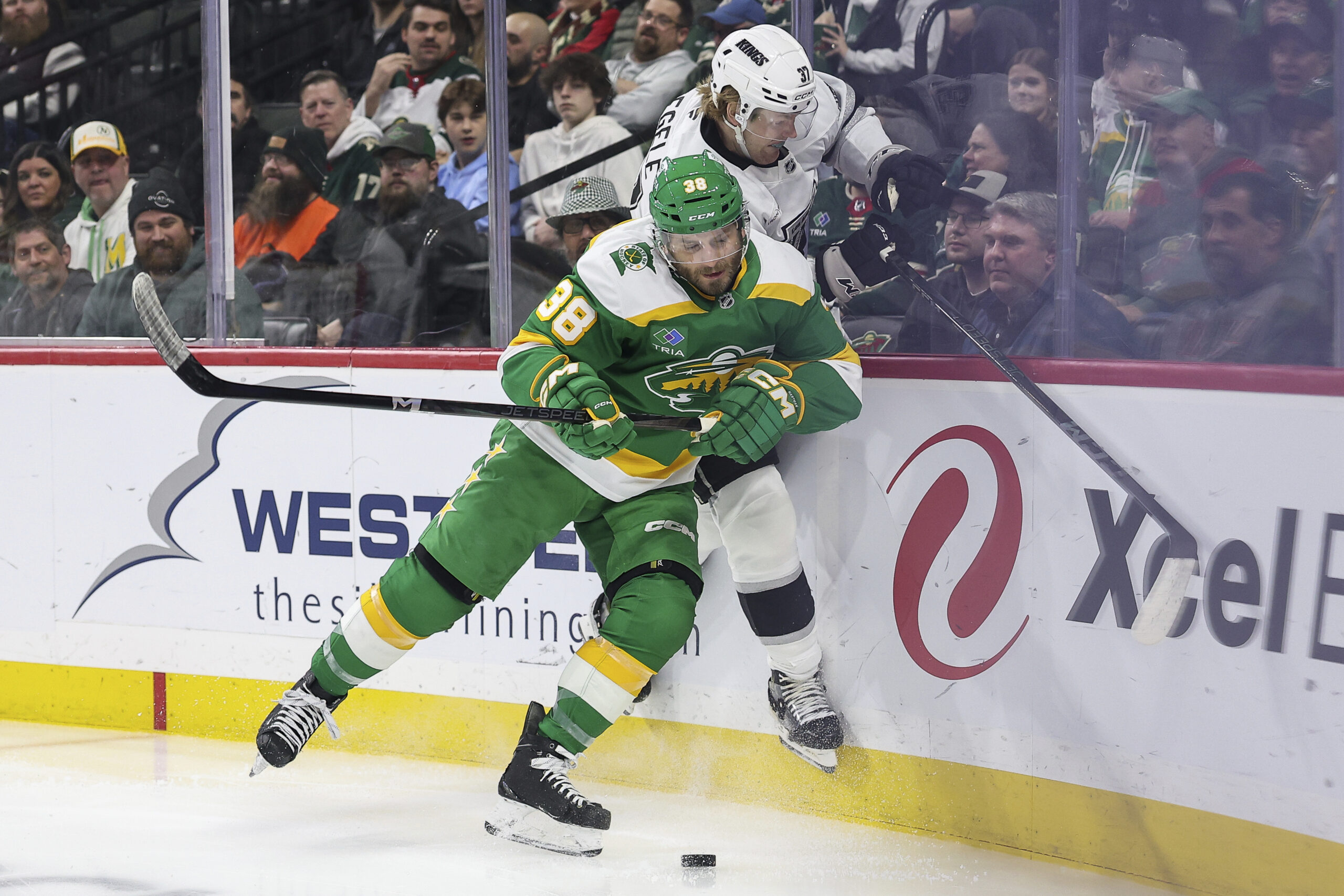 Minnesota Wild right wing Ryan Hartman, front, checks Kings left...