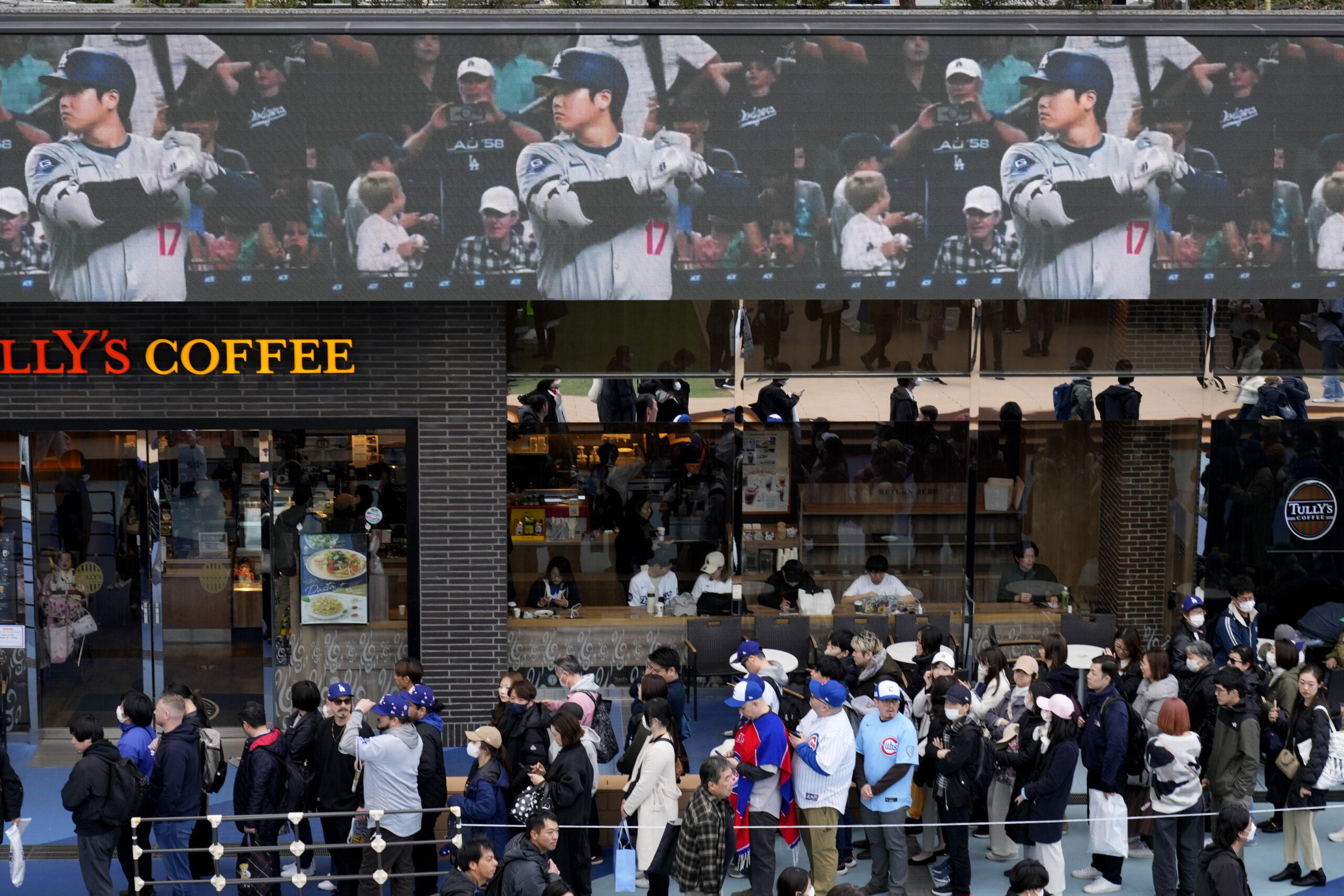 People wait in queue to enter an official shop before...