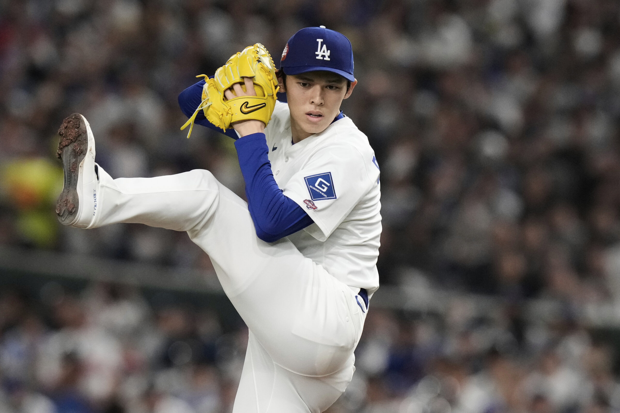 Dodgers starting pitcher Roki Sasaki winds up to deliver to...