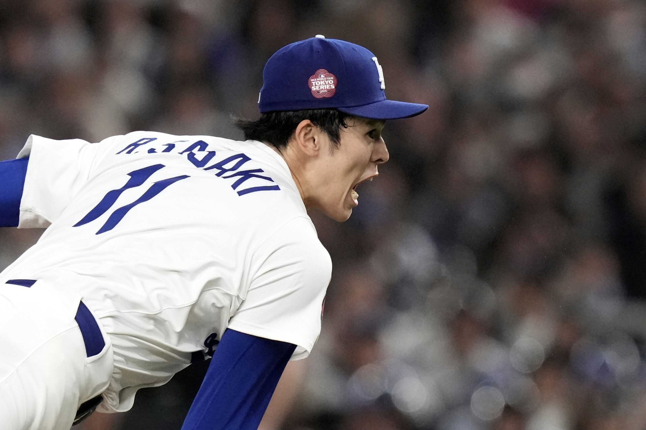 Dodgers pitcher Roki Sasaki follows through on his delivery to...