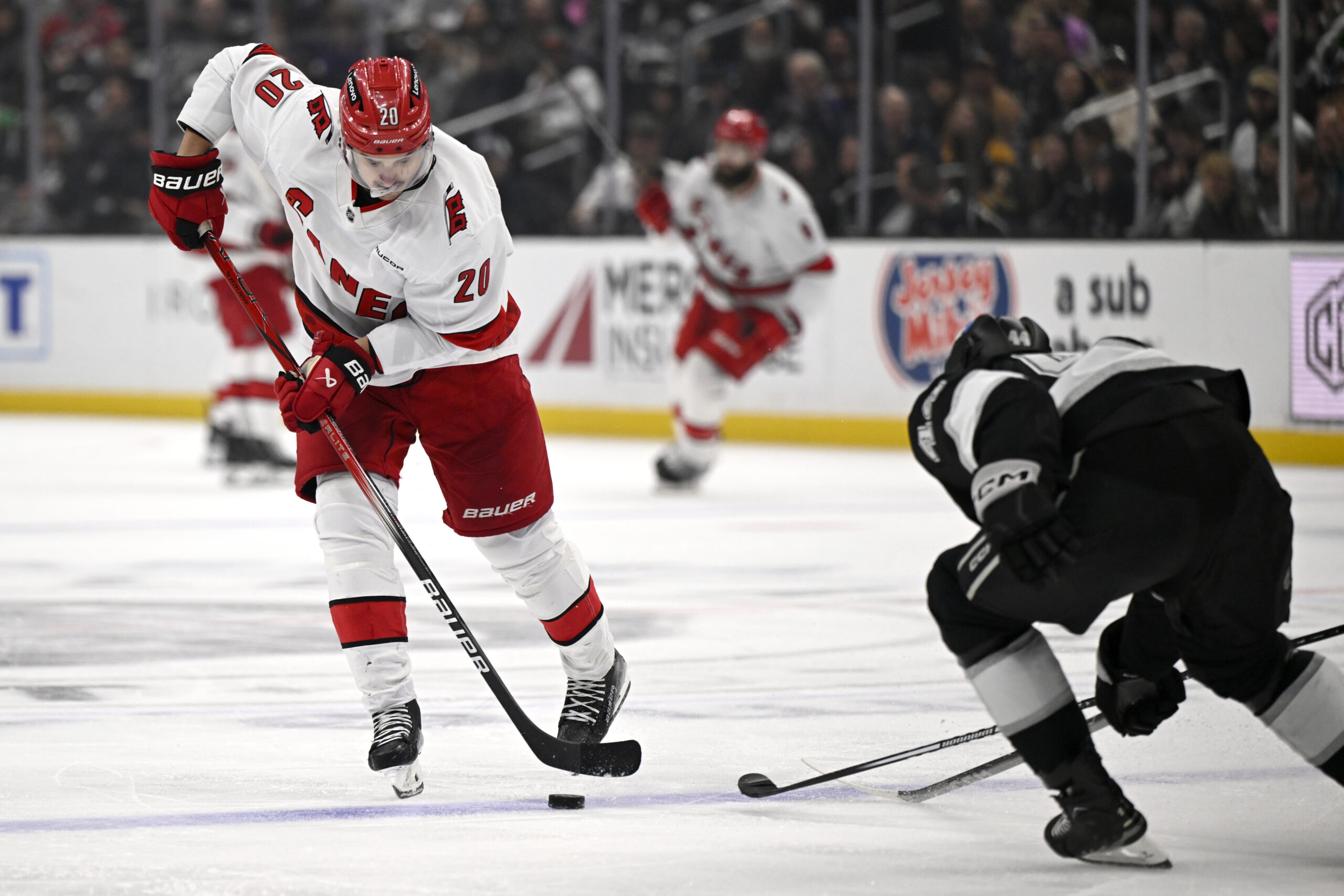 Carolina Hurricanes center Sebastian Aho (20) controls the puck past...