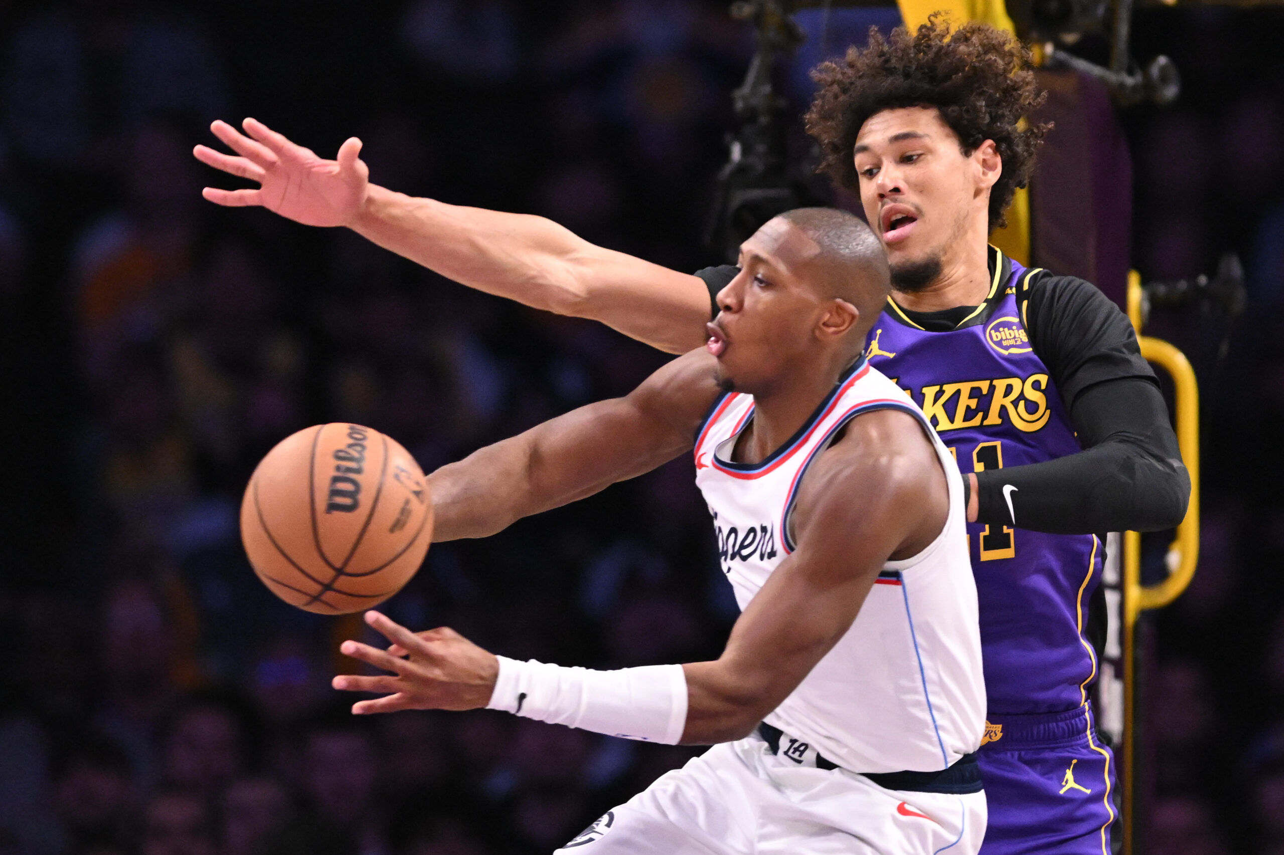 Clippers guard Kris Dunn, front, grabs a rebound in front...